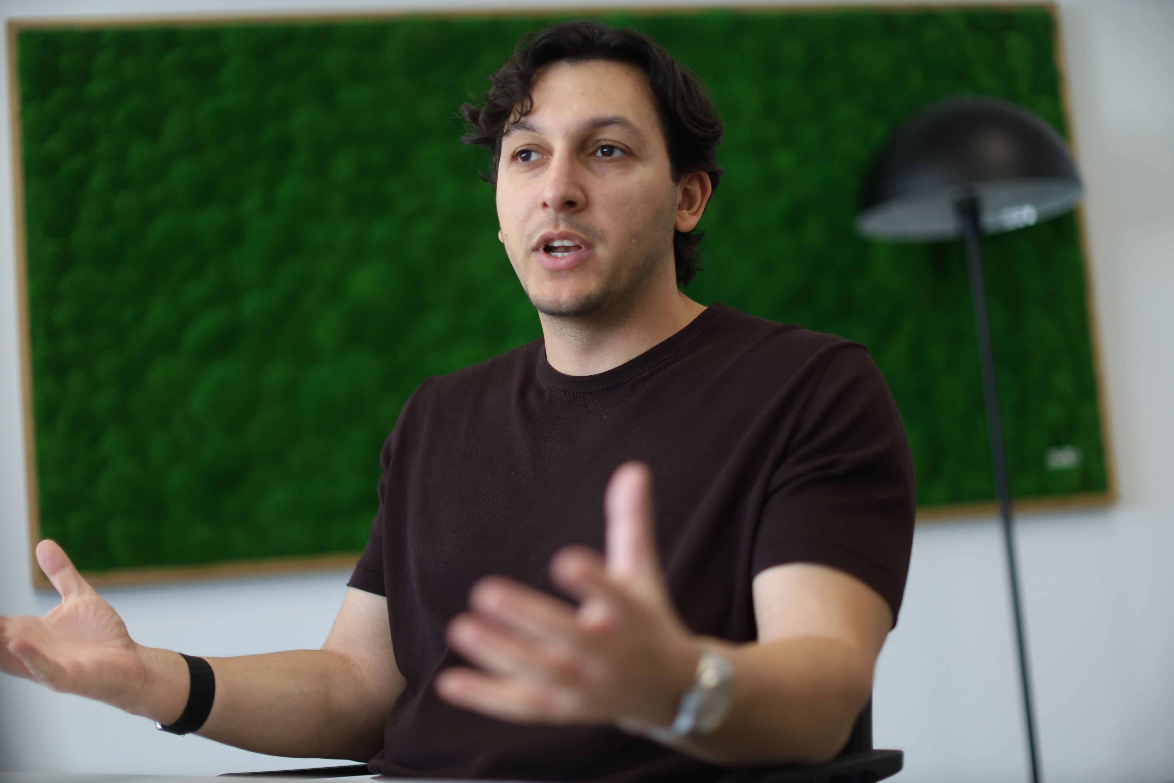 René Fergen beim Interview im Jupus-Sitz am Hohenstaufenring, während er beim Sprechen gestikuliert.