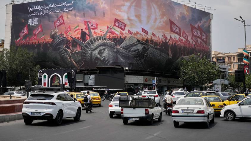 Teheran: Eine Plakatwand, auf der eine umgestürzte Freiheitsstatue und Menschenmengen mit iranischen und schiitischen Flaggen zu sehen sind.
