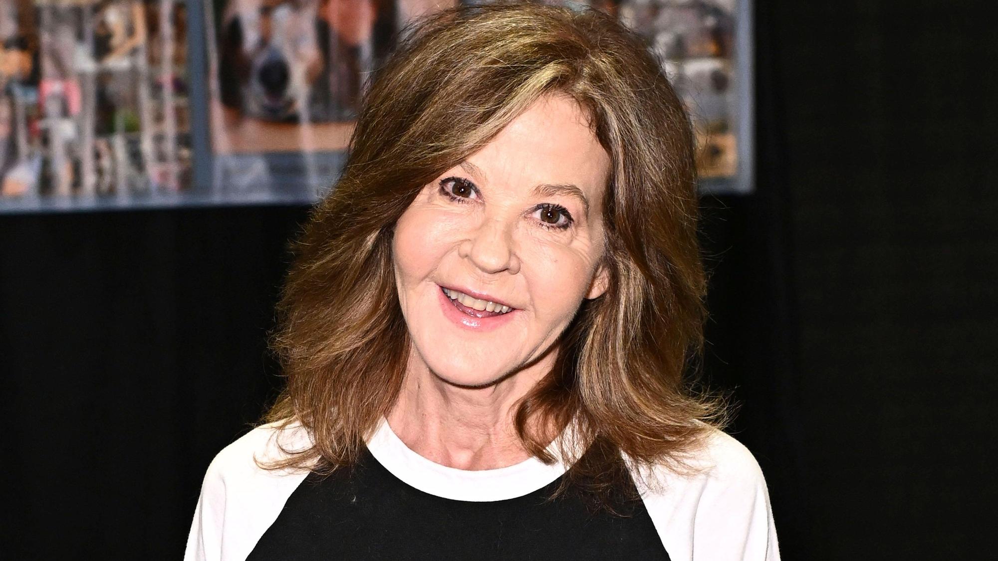 Linda Blair posiert und lächelt.