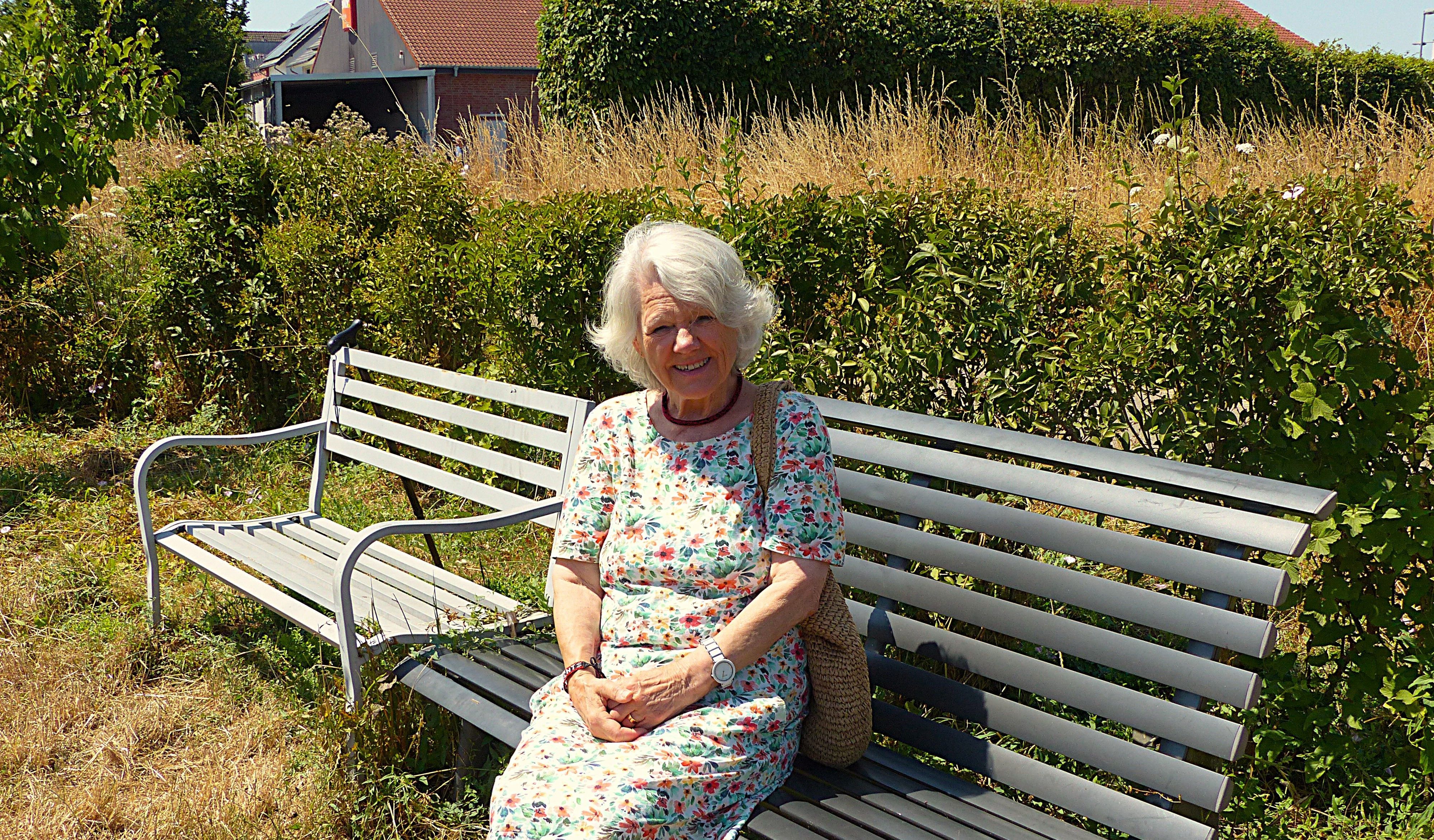 Das Foto zeigt eine Frau auf einer Bank.