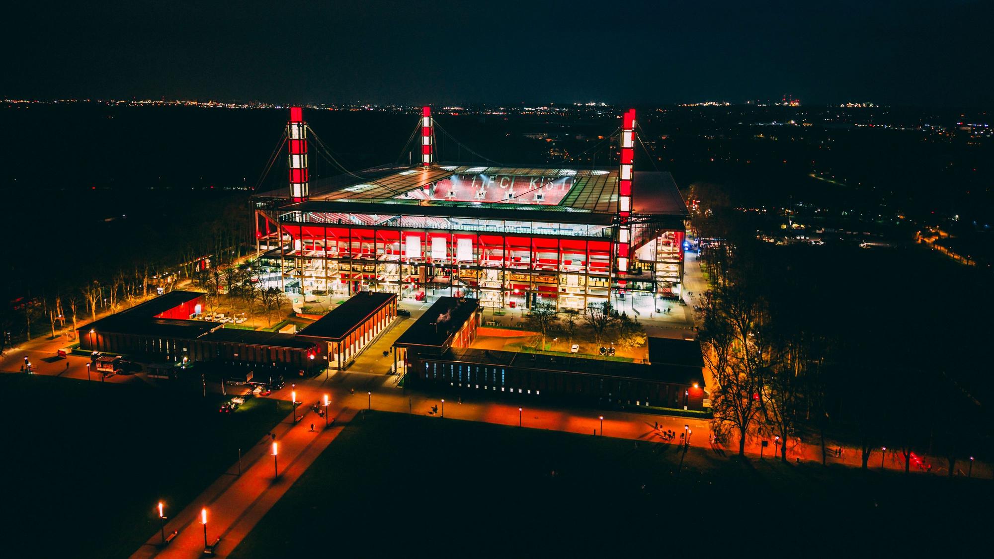 Luftaufnahme: beleuchtetes Rhein-Energie-Stadion von oben.