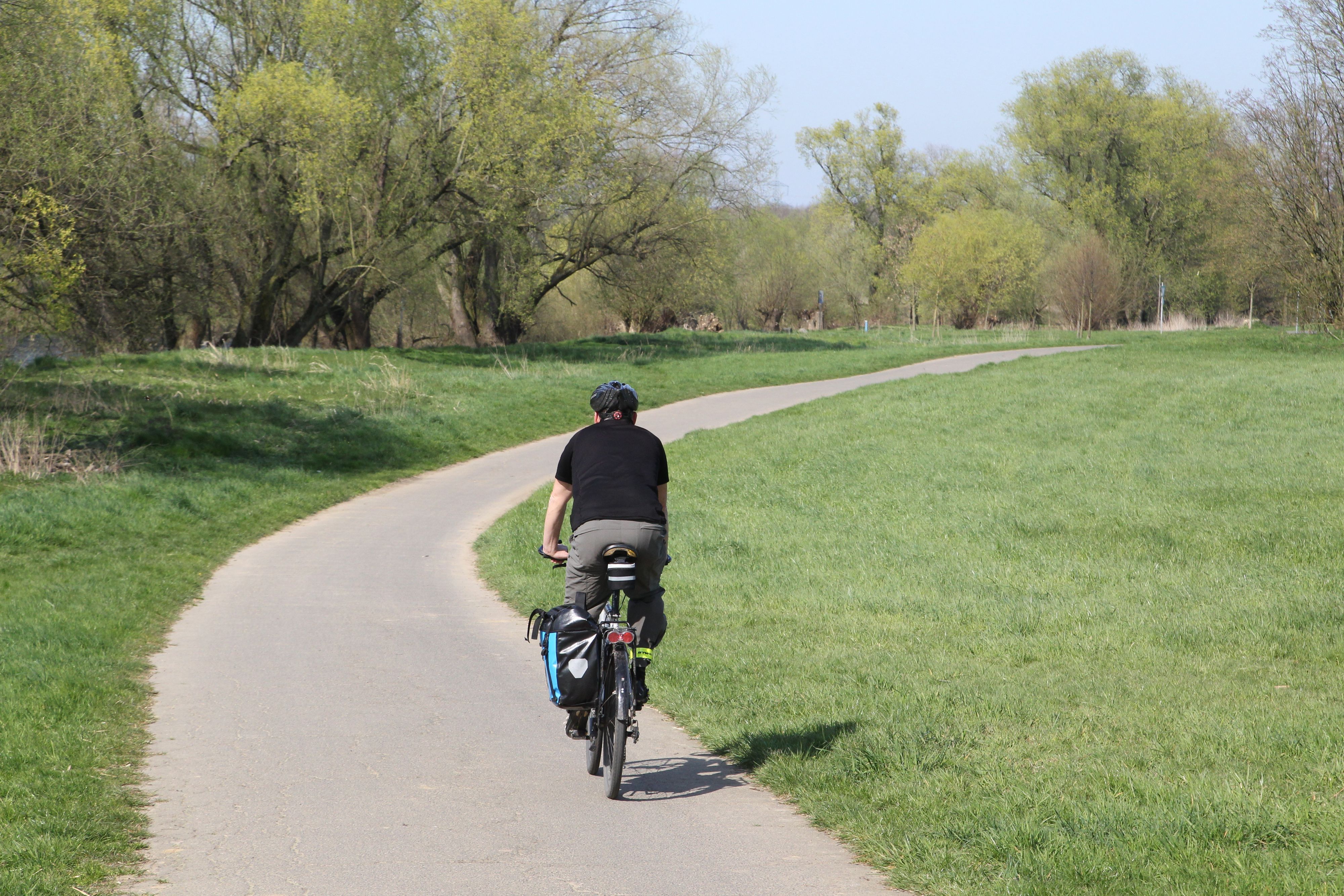 Ein Mann mit seinem Fahrrad auf einem Fahrradweg.