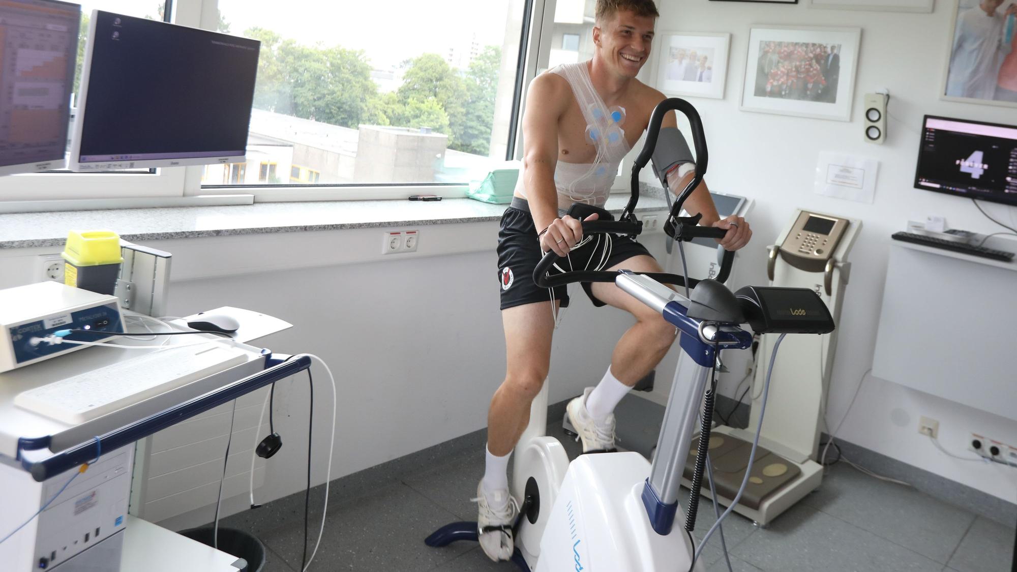 Ein Mann sitzt auf einem Cardio-Gerät.