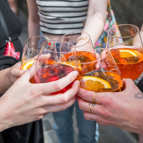 Fünf Personen stoßen mit ihren Gläsern mit Aperol Spritz an.