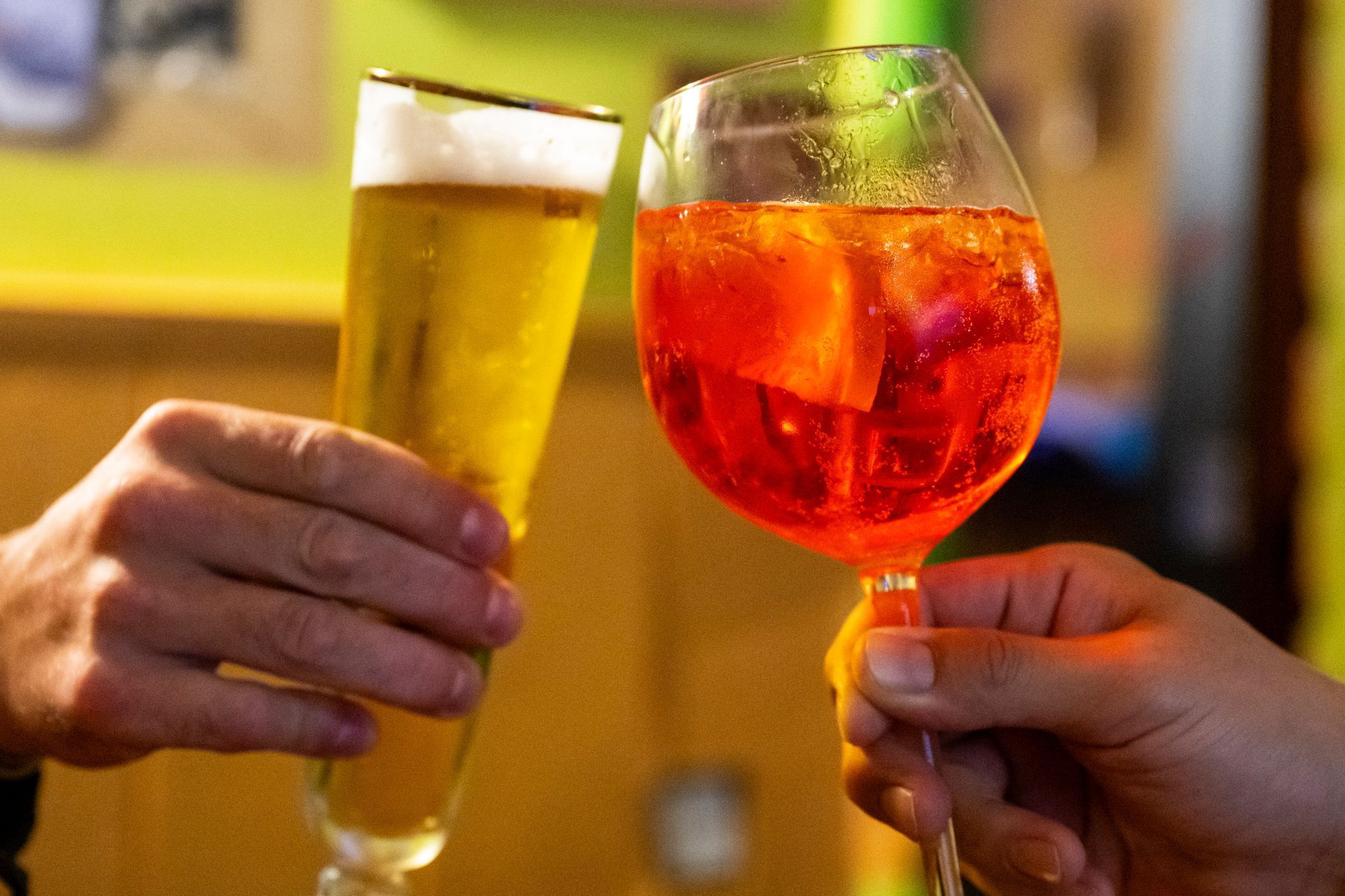 Aperol Spritz und ein Bierglas beim Prosten.