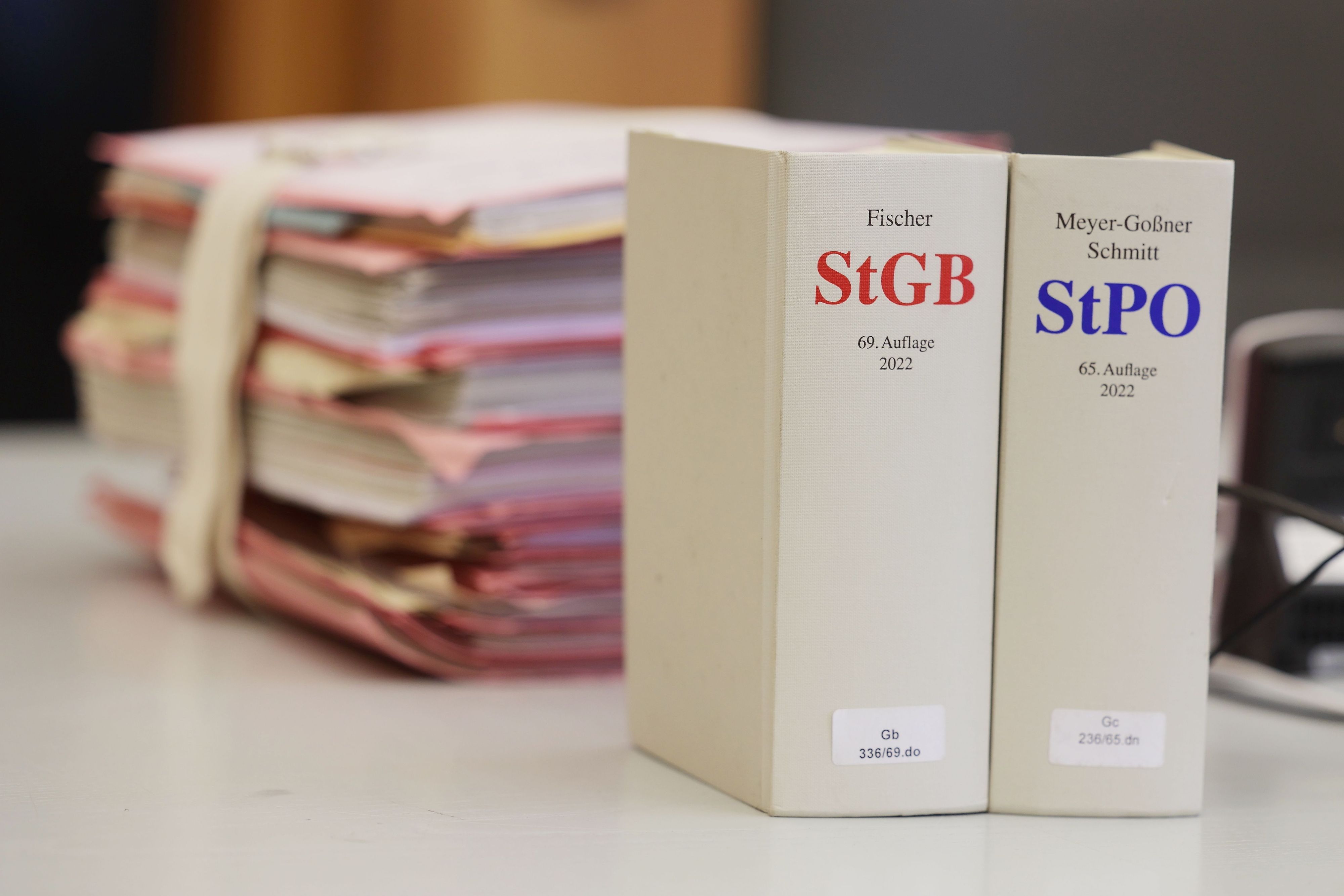 Gerichtsakten und Bücher zu Strafgesetzbuch und Strafprozessordnung liegen bzw. stehen auf einem Tisch im Landgericht.