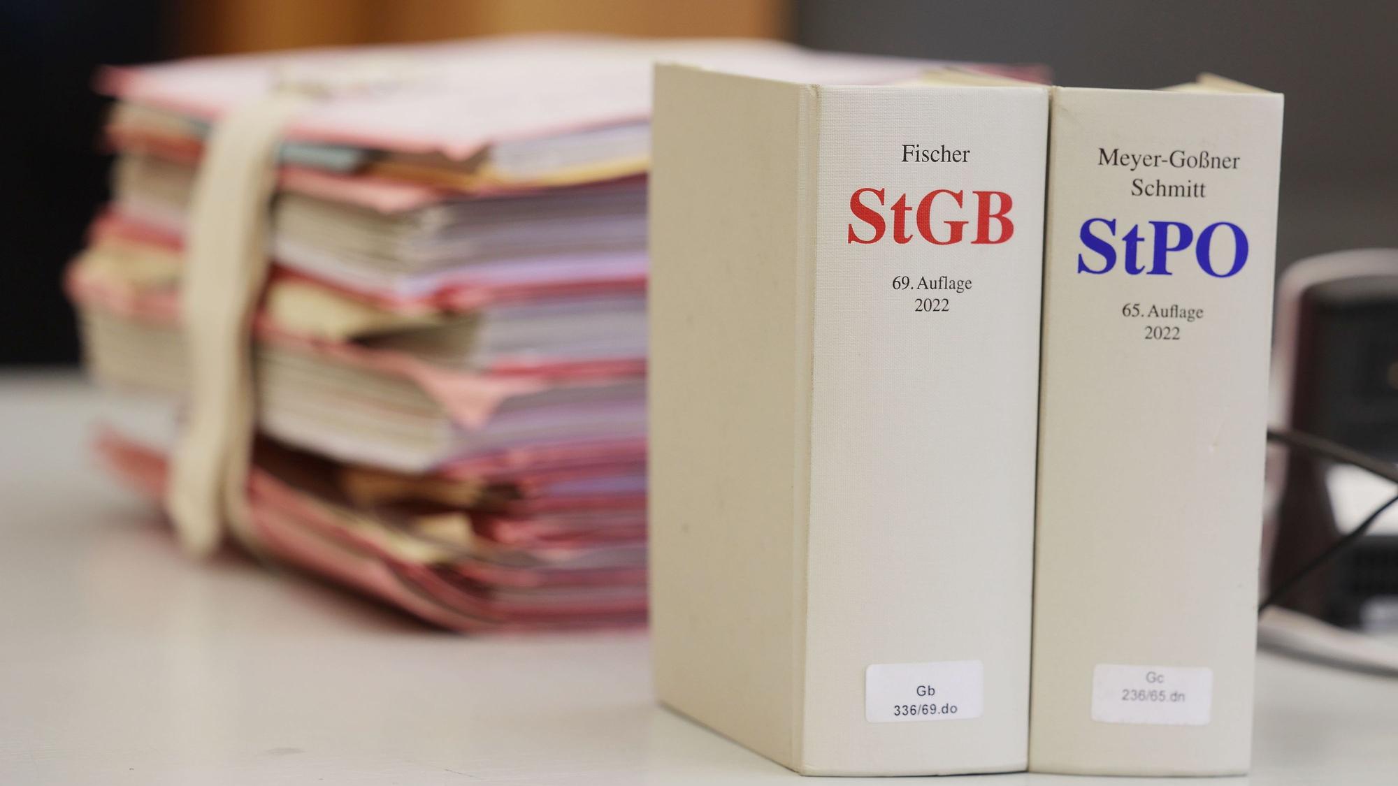 Gerichtsakten und Bücher zu Strafgesetzbuch und Strafprozessordnung liegen bzw. stehen auf einem Tisch im Landgericht.