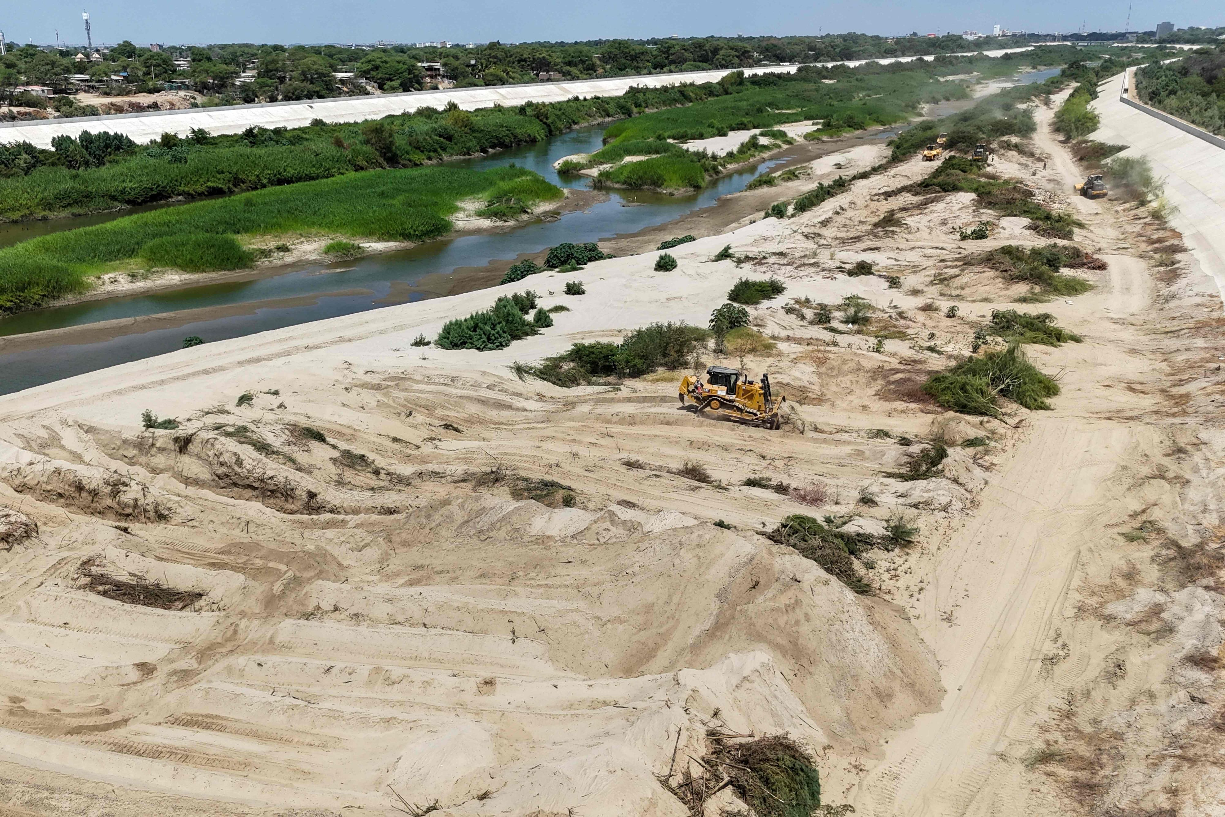 Ein Bulldozer arbeitet am Fluss Piura in Peru. Die Regierung verstärkt dort im August 2026 Schutzmaßnahmen gegen mögliche Folgen des sich verstärkenden El-Niño-Phänomens.