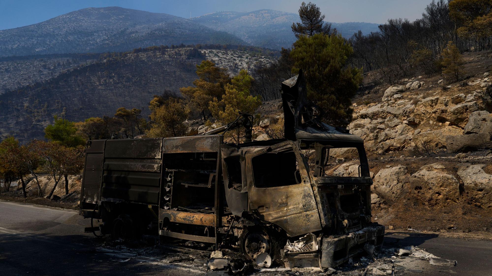 Ein durch einen Waldbrand zerstörtes Feuerwehrfahrzeug steht auf einer Straße in der Nähe von Porto Germeno, nordwestlich von Athen.