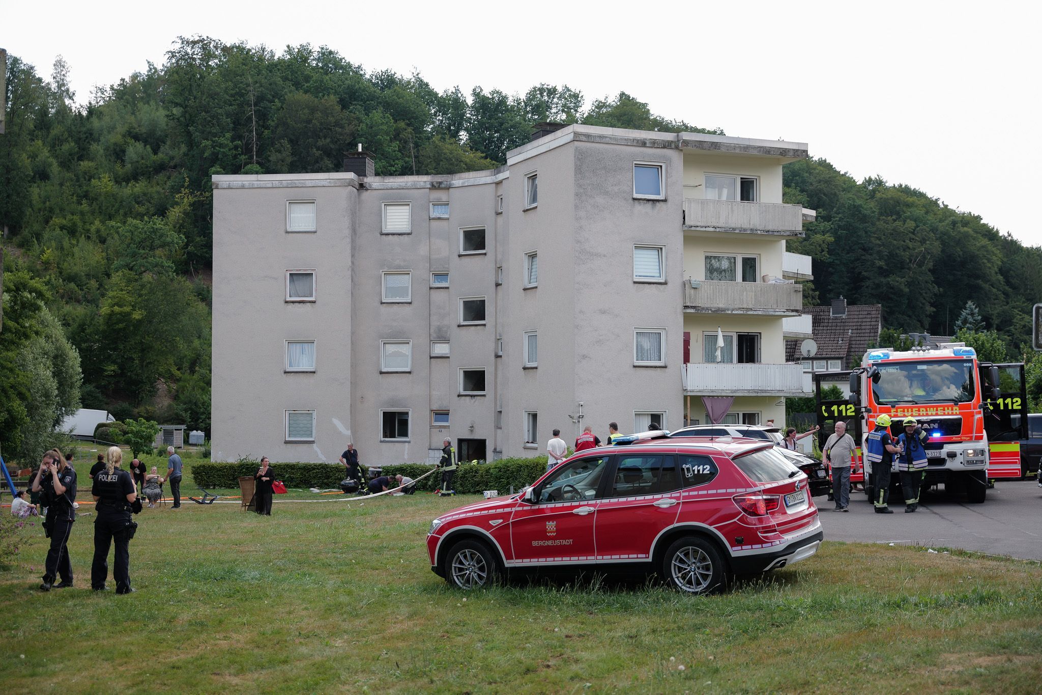 Feuerwehrautos vor einem dreigeschossigen Haus.