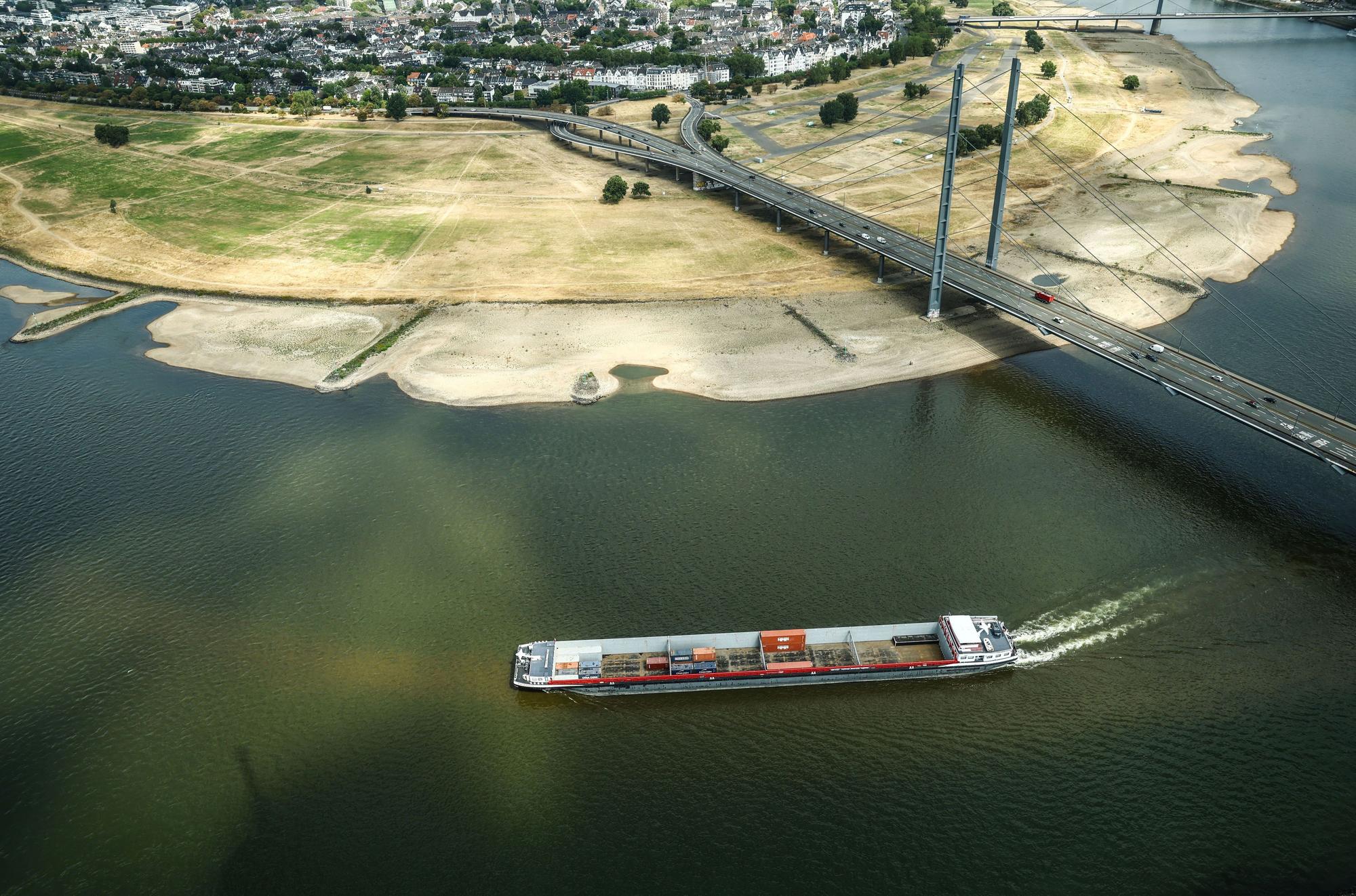 dpatopbilder - 05.08.2026, Nordrhein-Westfalen, Düsseldorf: Ein Containerschiff fährt mit geringer Ladung bei Niedrigwasser am Rheinknie in der nordrhein-westfälischen Landeshauptstadt vorbei. Foto: Oliver Berg/dpa +++ dpa-Bildfunk +++