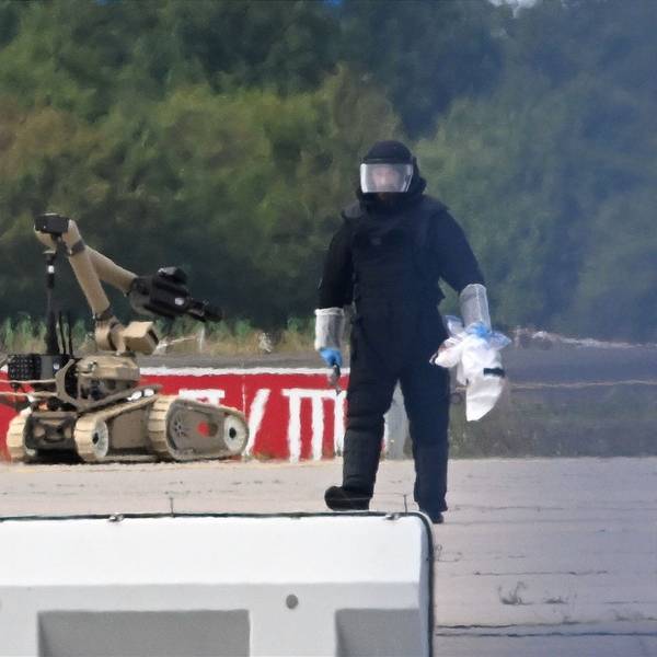 Ein Kriminaltechniker ist neben einem Sprengroboter in der Nähe eines ukrainischen Flugzeugs auf dem Flughafen Leipzig/Halle im Einsatz.