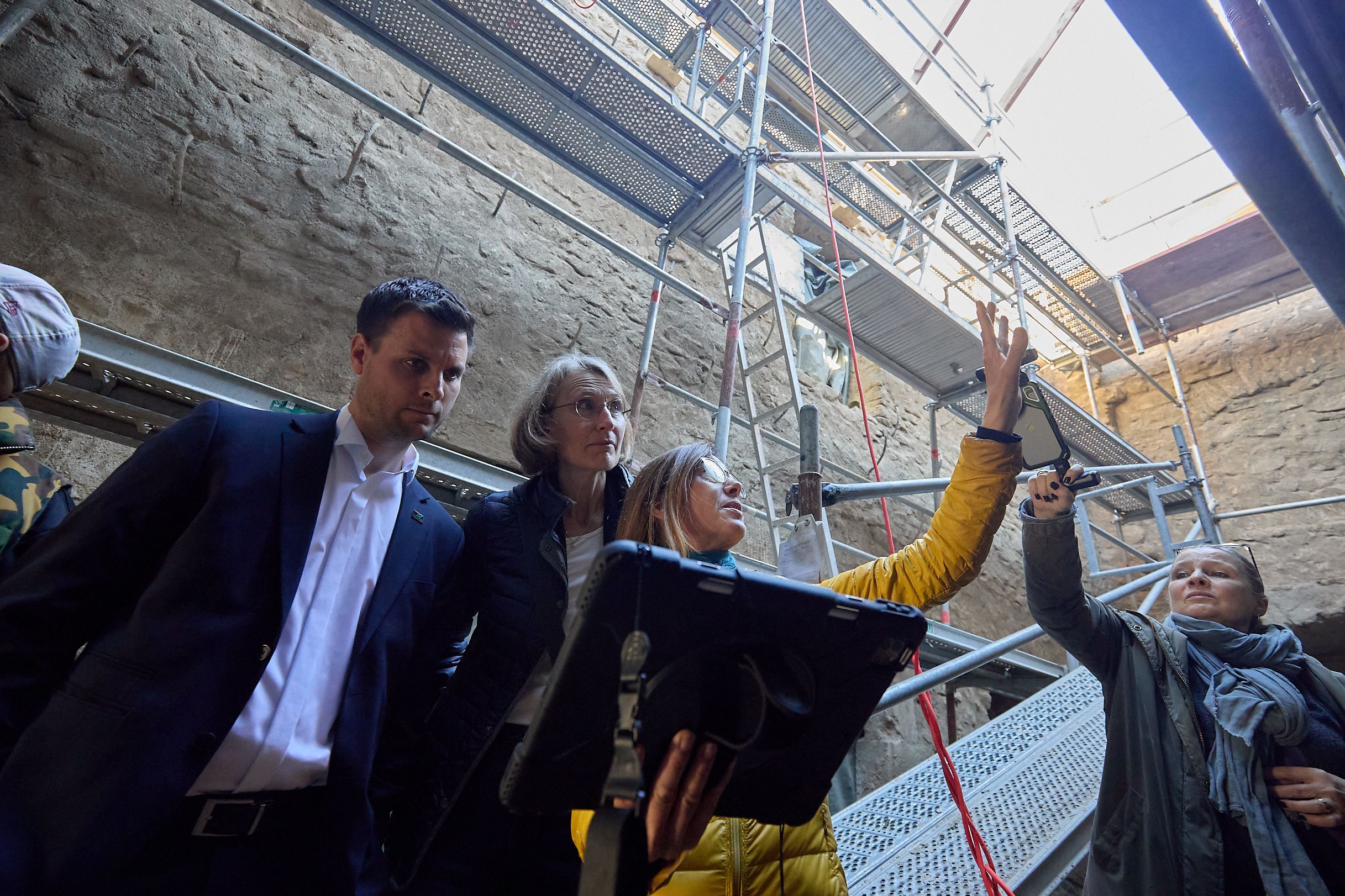 Die Expertin erklärt gestenreich Bauspuren in einer alten Burg.