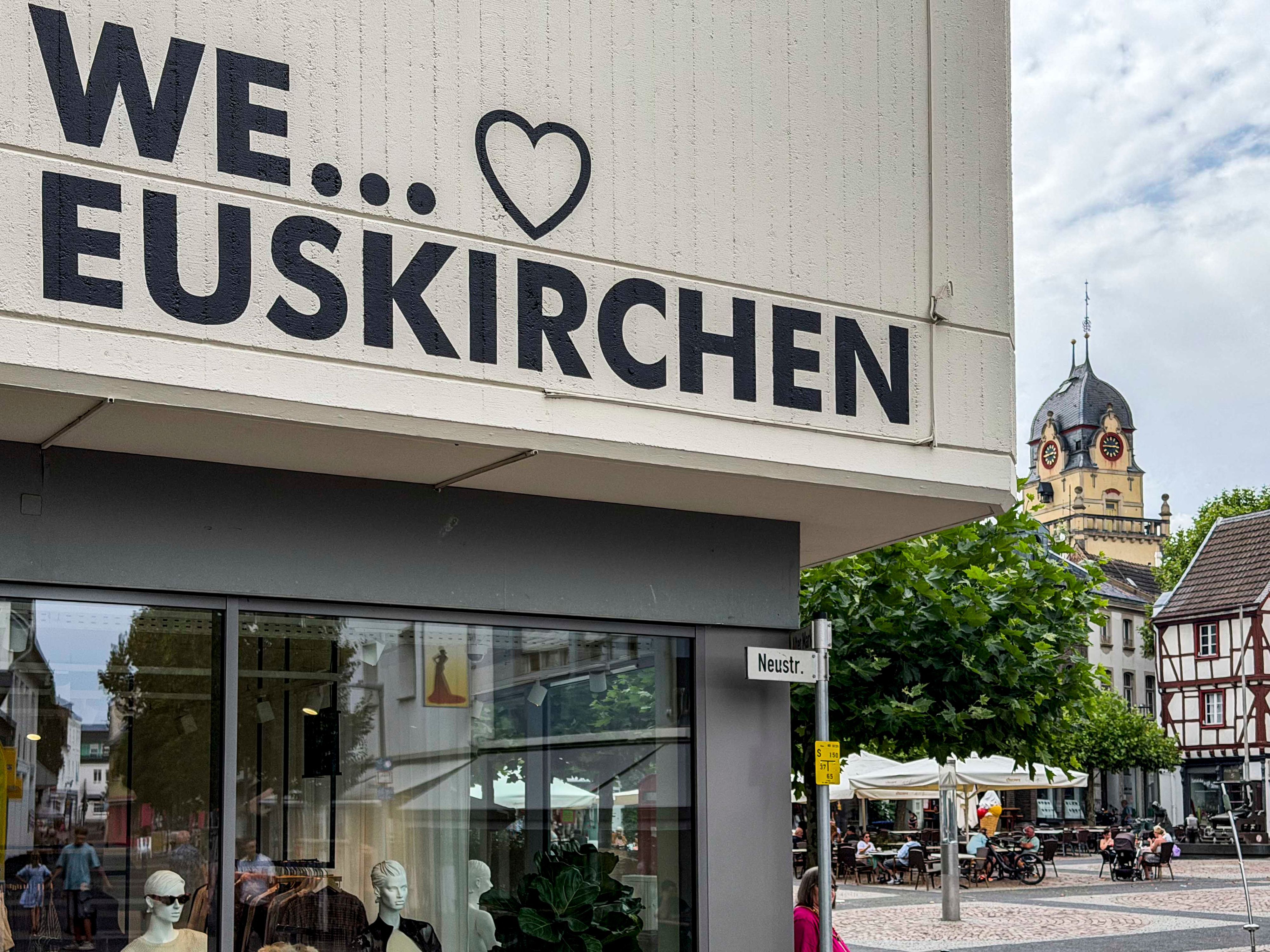 Das Bild zeigt den Aufdruck „We love Euskirchen“ auf einer Fassade. Im Hintergrund ist das Alte Rathaus zu sehen.