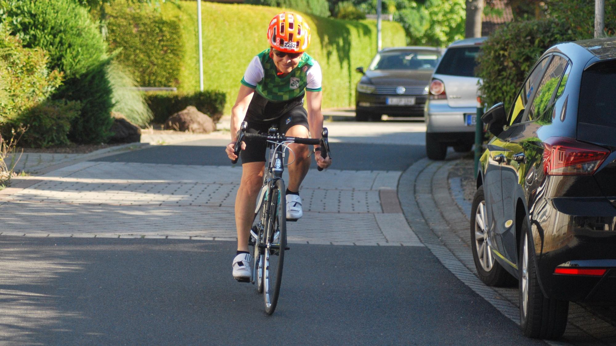 Elisabeth Bachem fährt mit ihrem Rennrad über eine Straße.