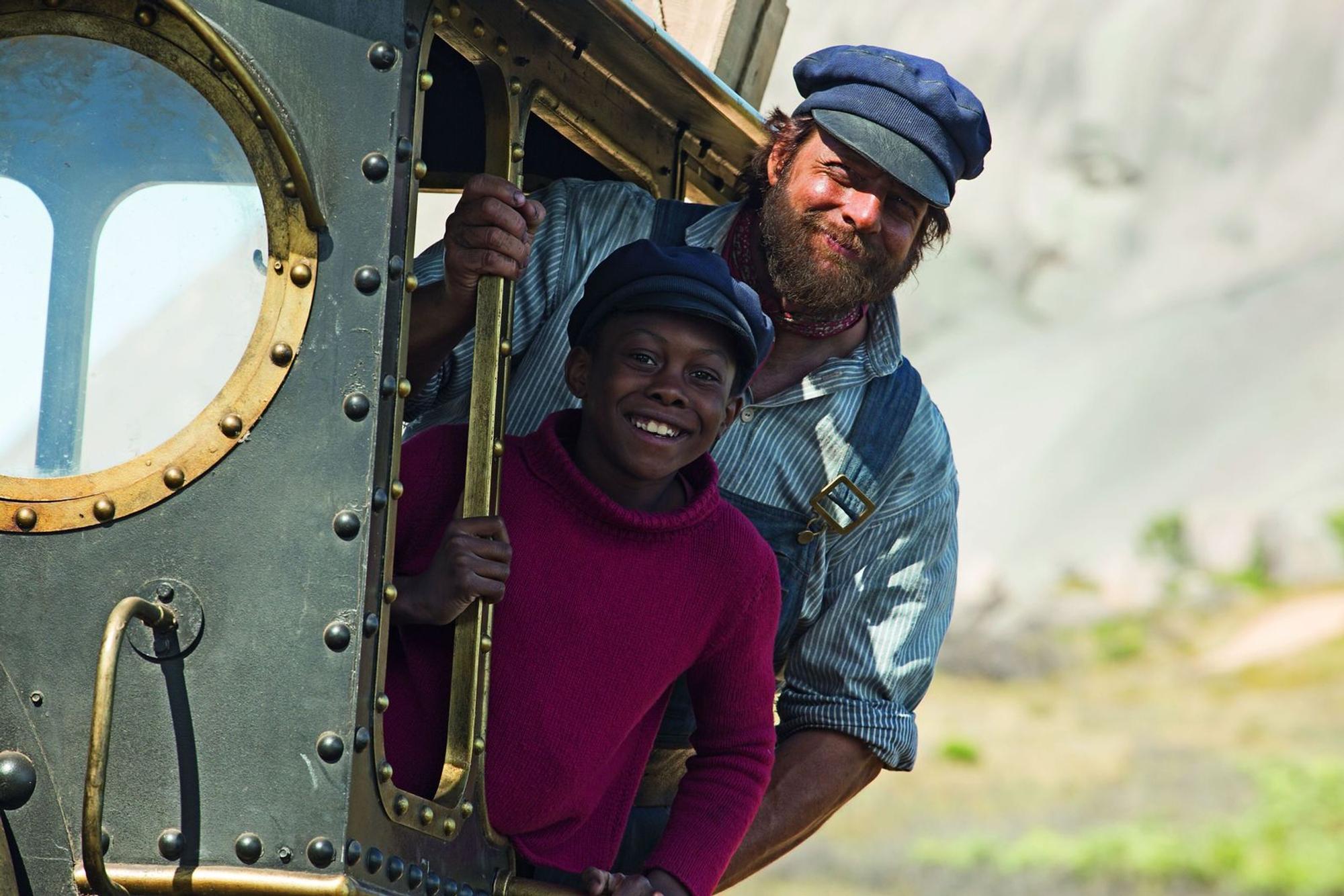 Jim Knopf (Solomon Gordon, vorne) und Lukas (Henning Baum) sind mit Lokomotive Emma unterwegs. (Bild: 2018 RAT PACK FILMPRODUKTION GMBH / MALAO FILM INC. / WARNER BROS ENTERTAINMENT GMBH.)