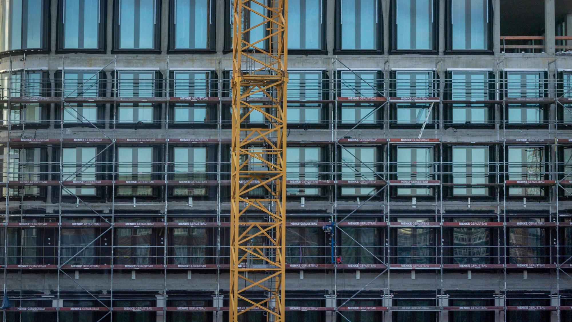 Ein Kran und ein Gerüst vor einem Gebäude in Berlin.