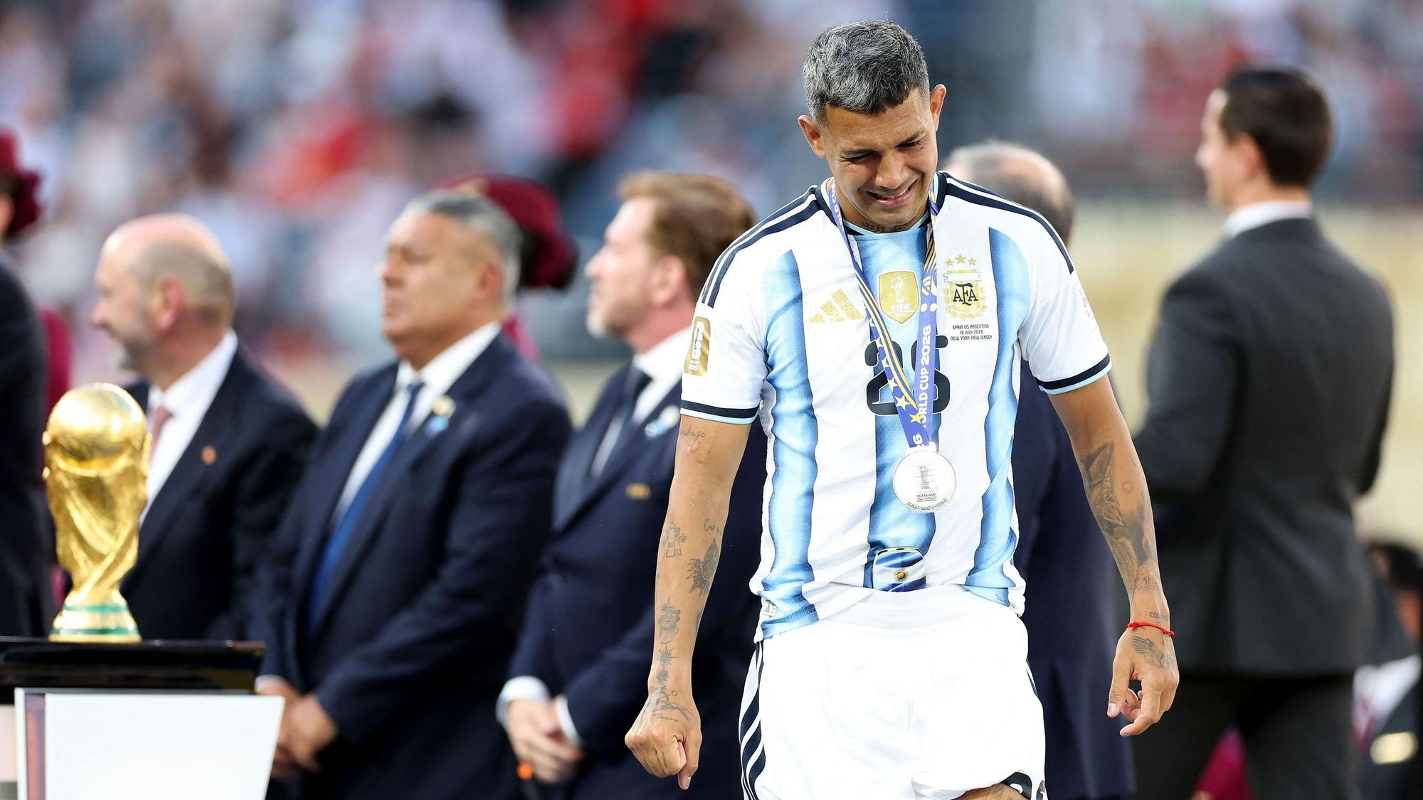 EAST RUTHERFORD, NEW JERSEY - JULY 19: Facundo Medina #25 of Argentina walks past the FIFA World Cup Winner's Trophy at the award ceremony following the FIFA World Cup 2026 Final match between Spain and Argentina at New York New Jersey Stadium on July 19, 2026 in East Rutherford, New Jersey. Dan Mullan/Getty Images/AFP (Photo by Dan Mullan / GETTY IMAGES NORTH AMERICA / Getty Images via AFP)