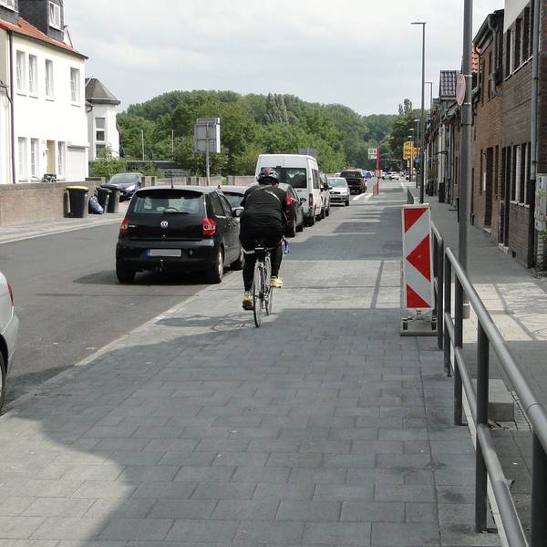 Ein Radfahrer fährt auf der Neusser Landstraße in Worringen, kurz nach Generalinstandsetzung (Abschnitt 1).