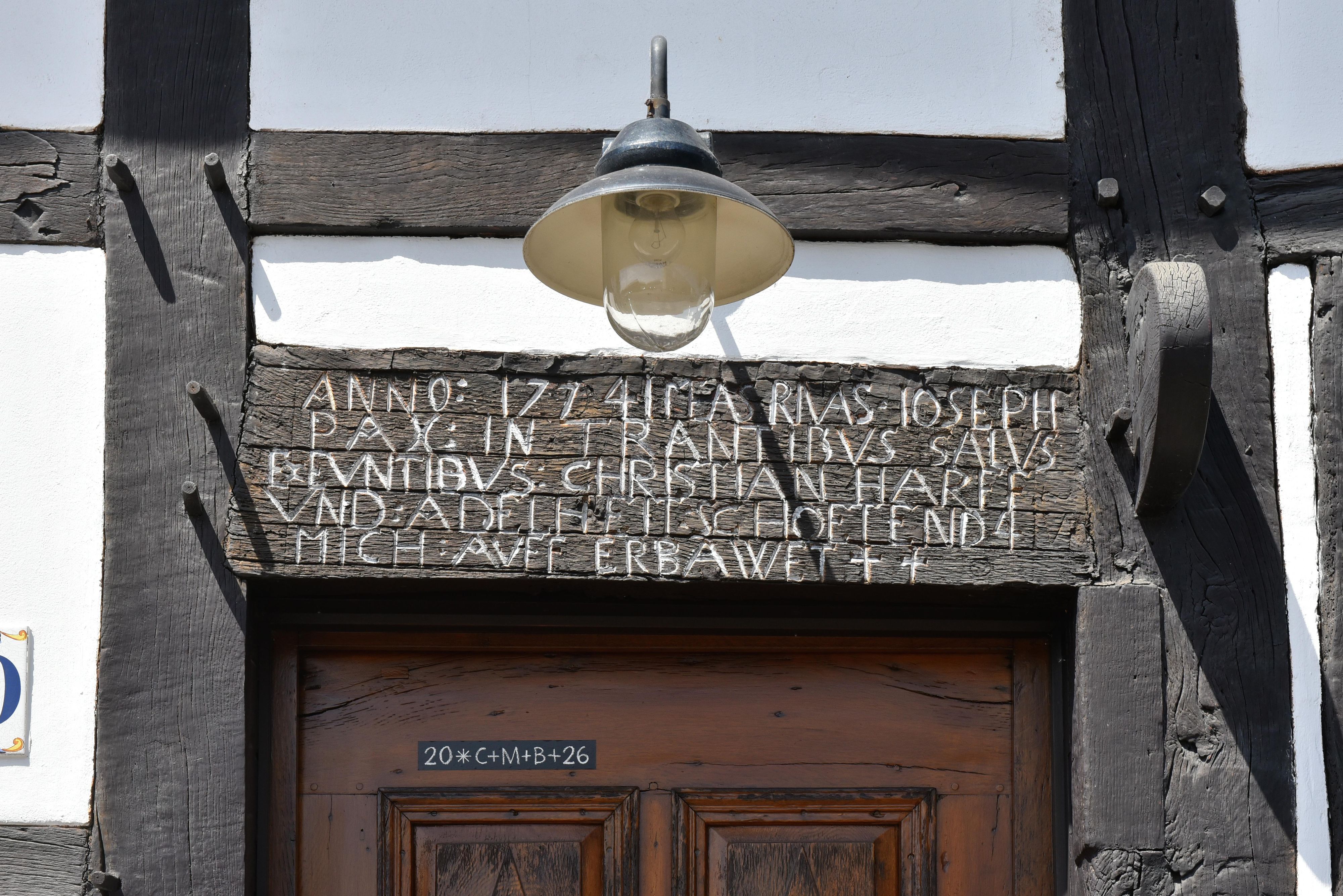 Ein alter Holzbalken aus dem Jahr 1774 mit einer Inschrift