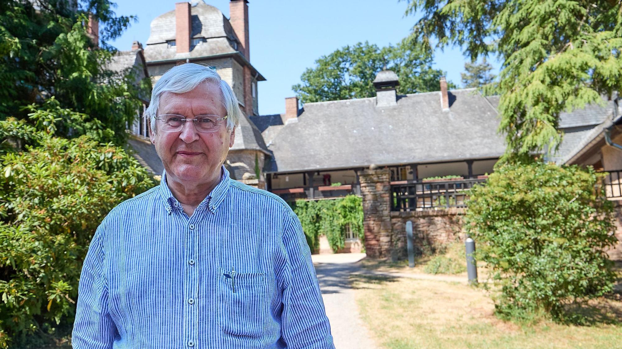 Ein Mann steht vor seinem Gutshaus im Wald bei Mechernich.