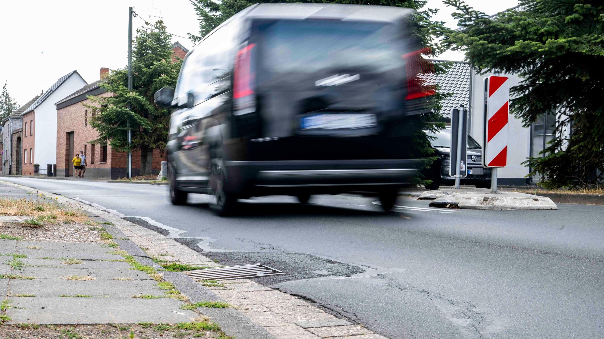 Das Bild zeigt ein Auto, das durch Palmersheim fährt. Durch die Langzeitbelichtung ist es verschwommen.