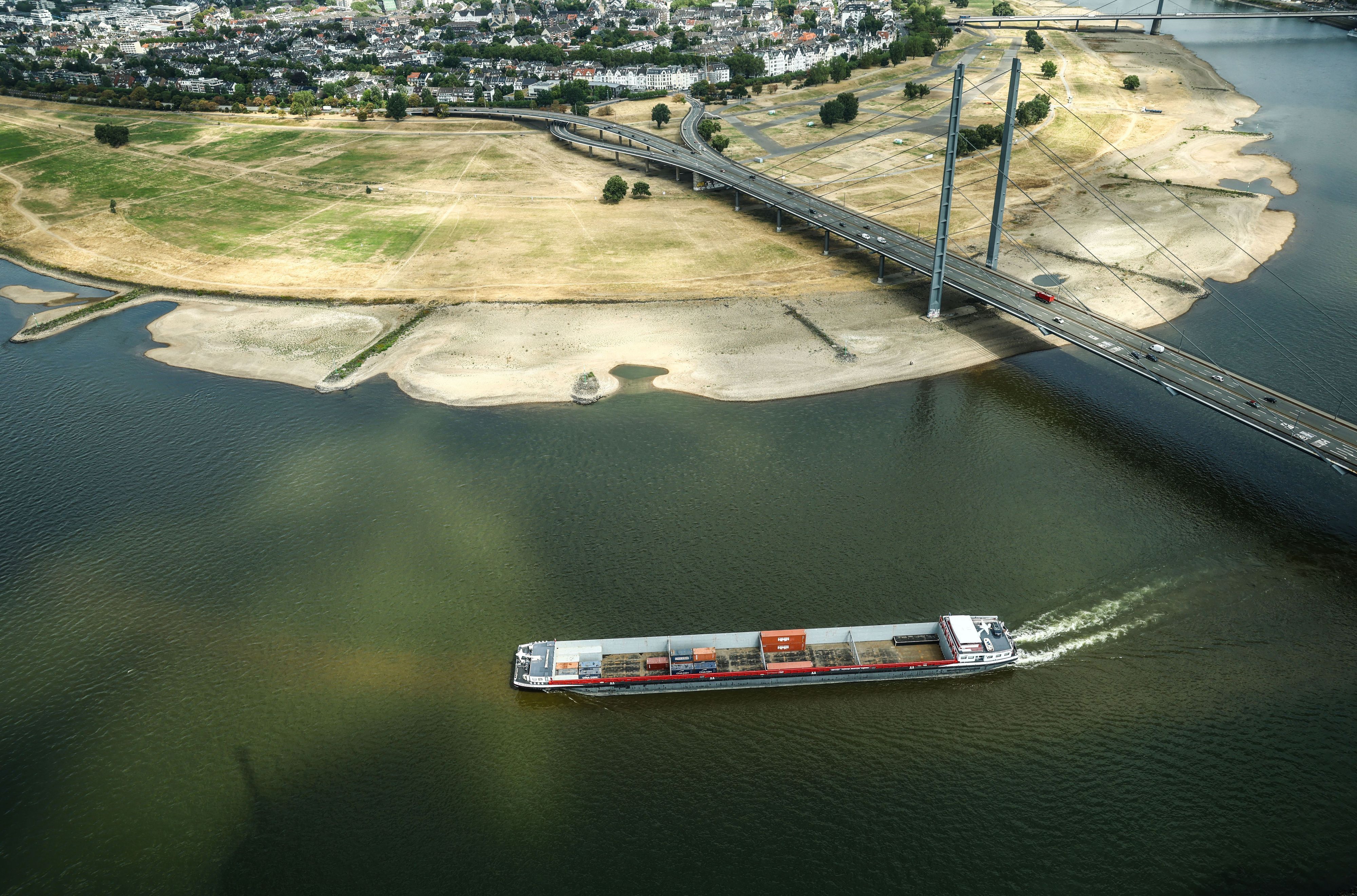 Ein Containerschiff fährt mit geringer Ladung bei Niedrigwasser am Rheinknie in Düsseldorf vorbei.