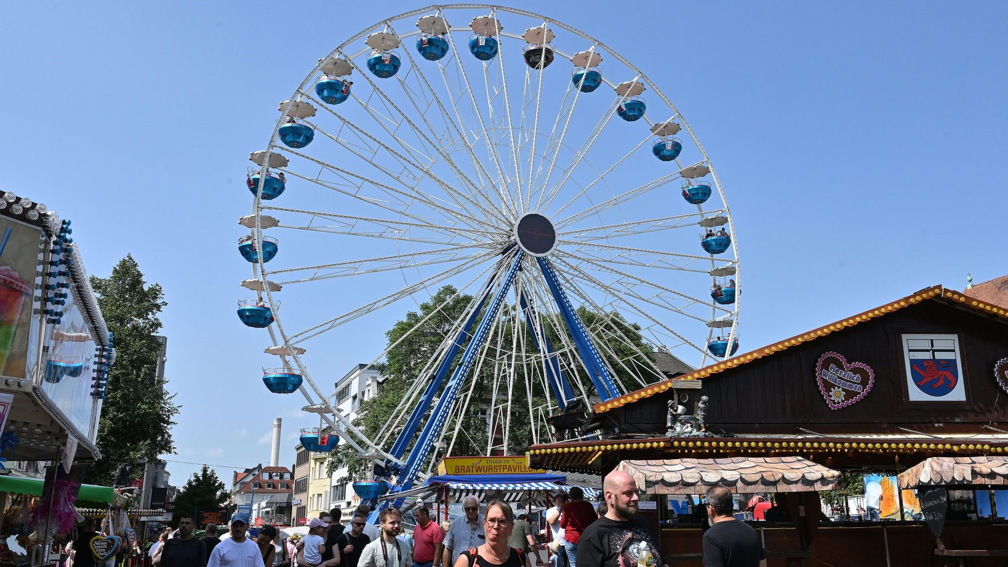 Ein Riesenrad steht in der Gladbacher Stadtmitte, davor Buden und Kirmesbesucher.