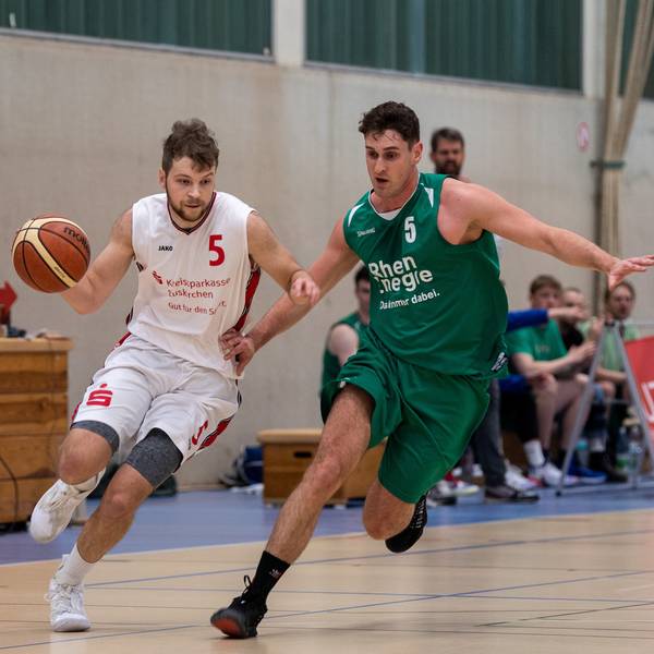 Das Bild zeigt Basketballer Philipp Greuel, wie er mit Tempo an einem Gegenspieler vorbeizieht.