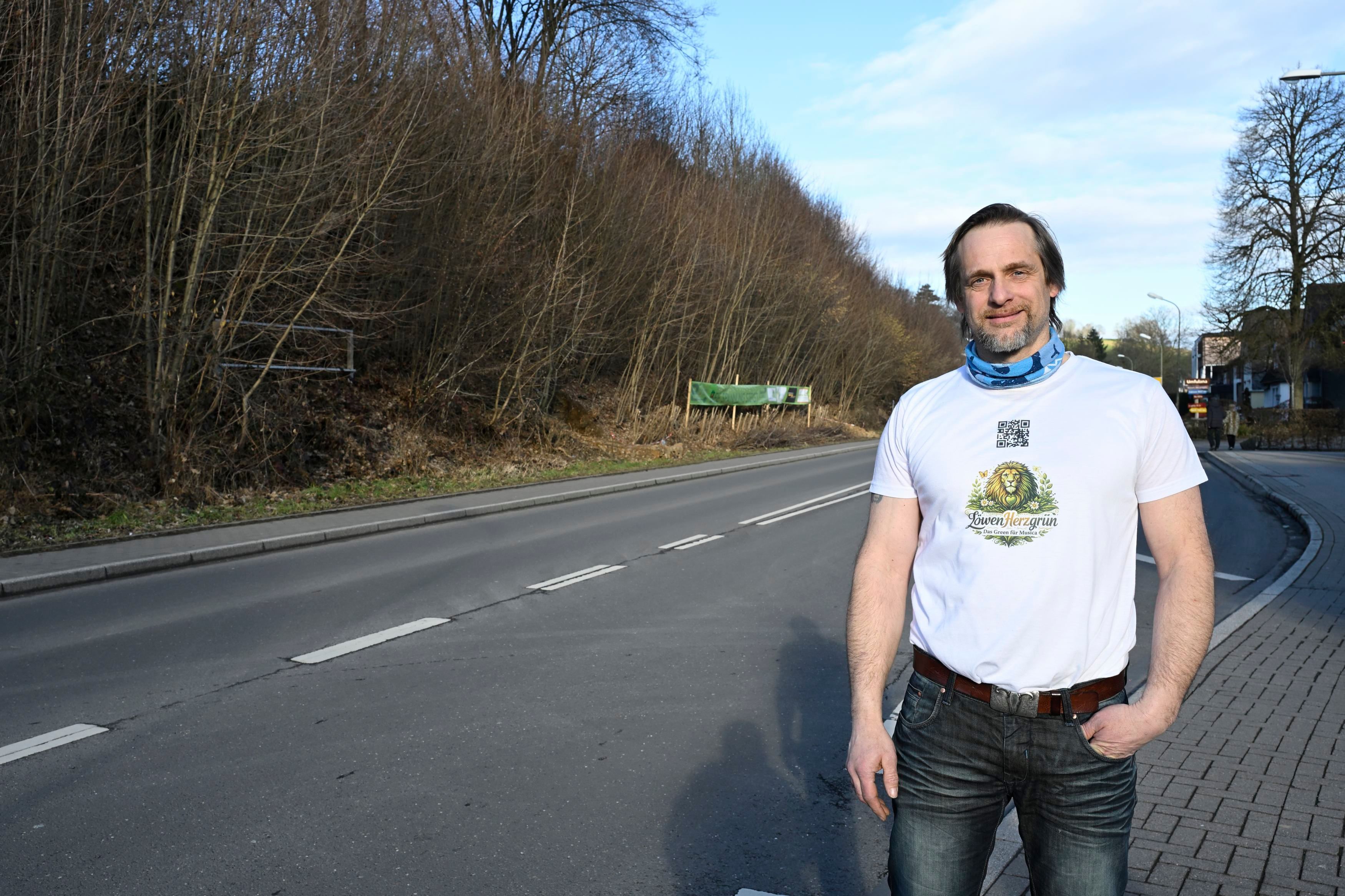 Patrick Pütz trägt ein weißes T-Shirt und eine dunkle Jeans.