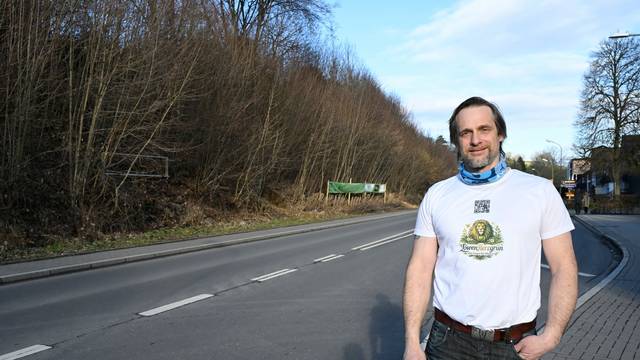 Patrick Pütz trägt ein weißes T-Shirt und eine dunkle Jeans.