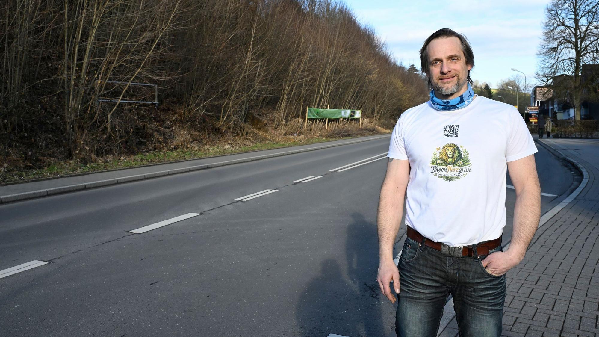 Patrick Pütz trägt ein weißes T-Shirt und eine dunkle Jeans.