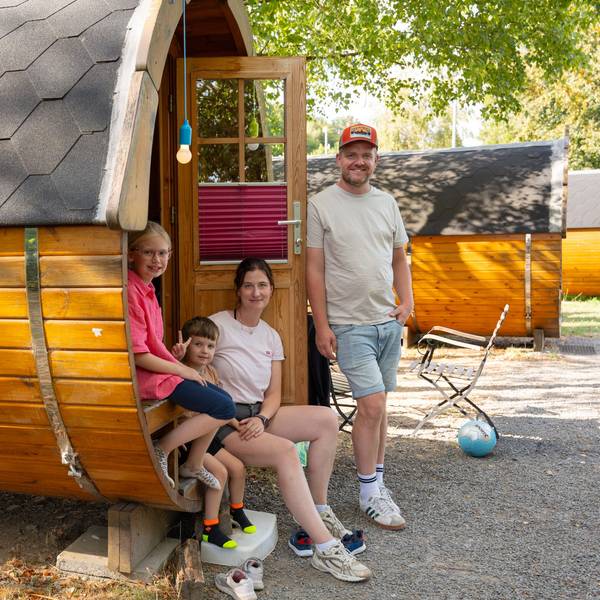Eine Familie steht an einem Schlaf-Fass.