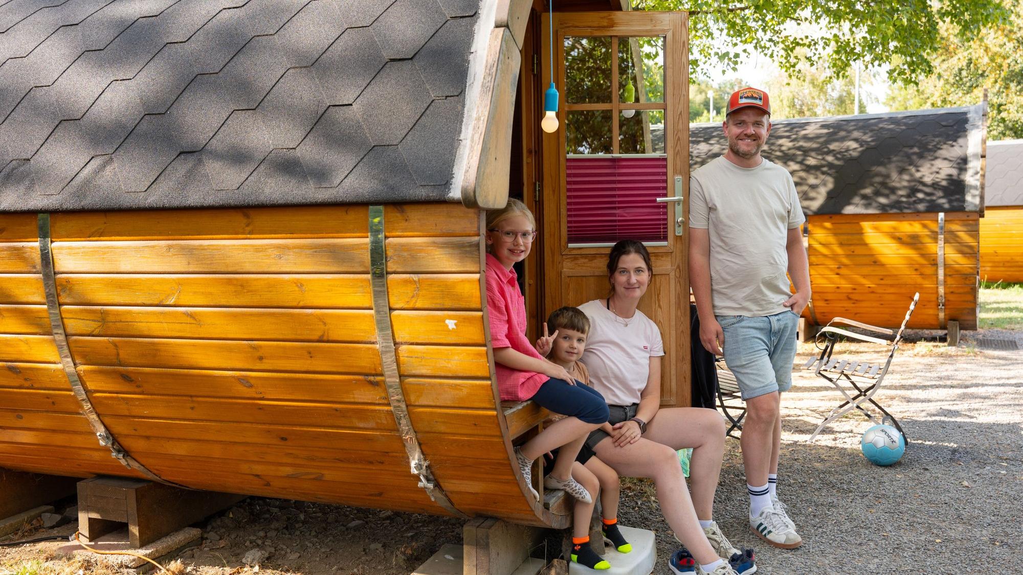 Eine Familie steht an einem Schlaf-Fass.