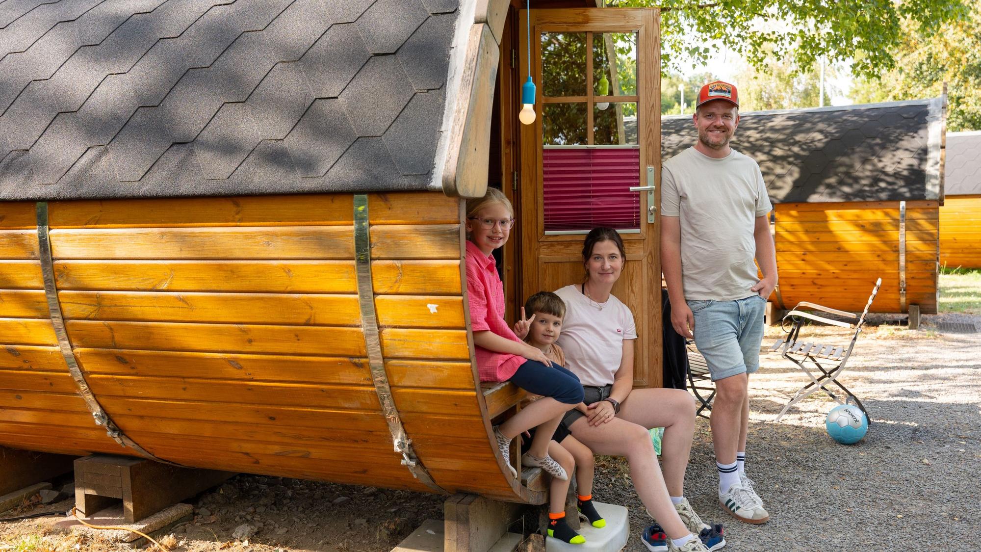 Eine Familie steht an einem Schlaf-Fass.
