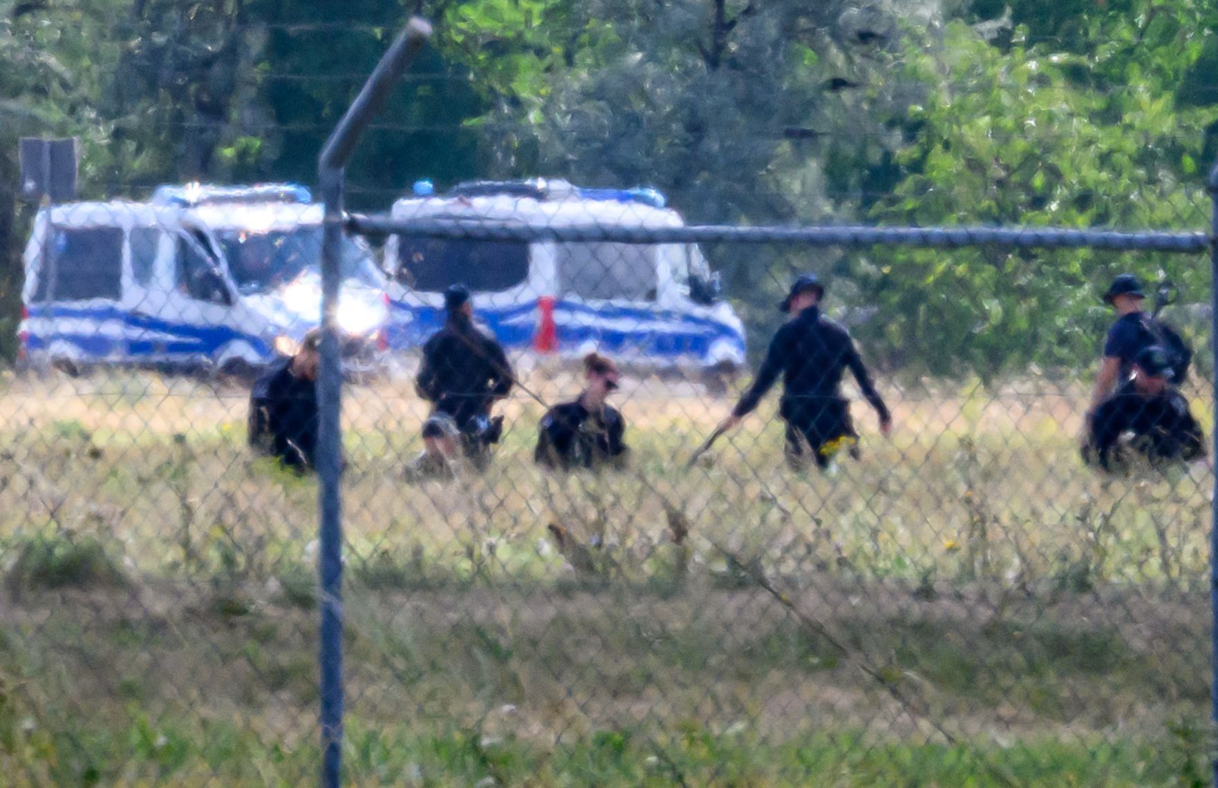 Einsatzkräfte der Polizei durchsuchen das Gelände abseits der Landebahn Nord auf dem Gelände des Flughafens Leipzig/Halle.