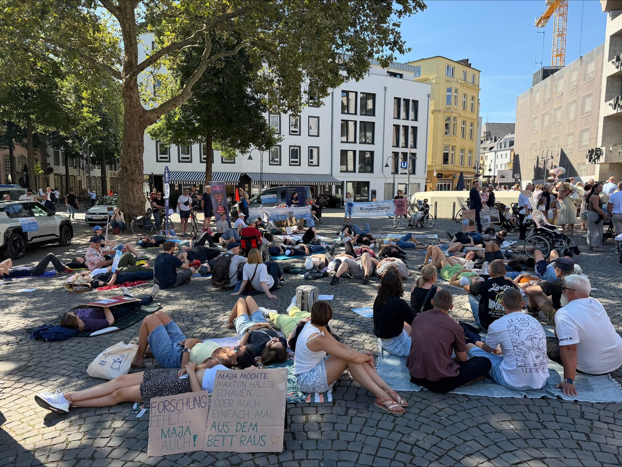 Bei der Liegend-Demo haben Menschen in Köln auf die Krankheit ME/CFS aufmerksam gemacht. Oft verbringen die Betroffenen den Tag im Bett – in abgedunkelten Räumen.