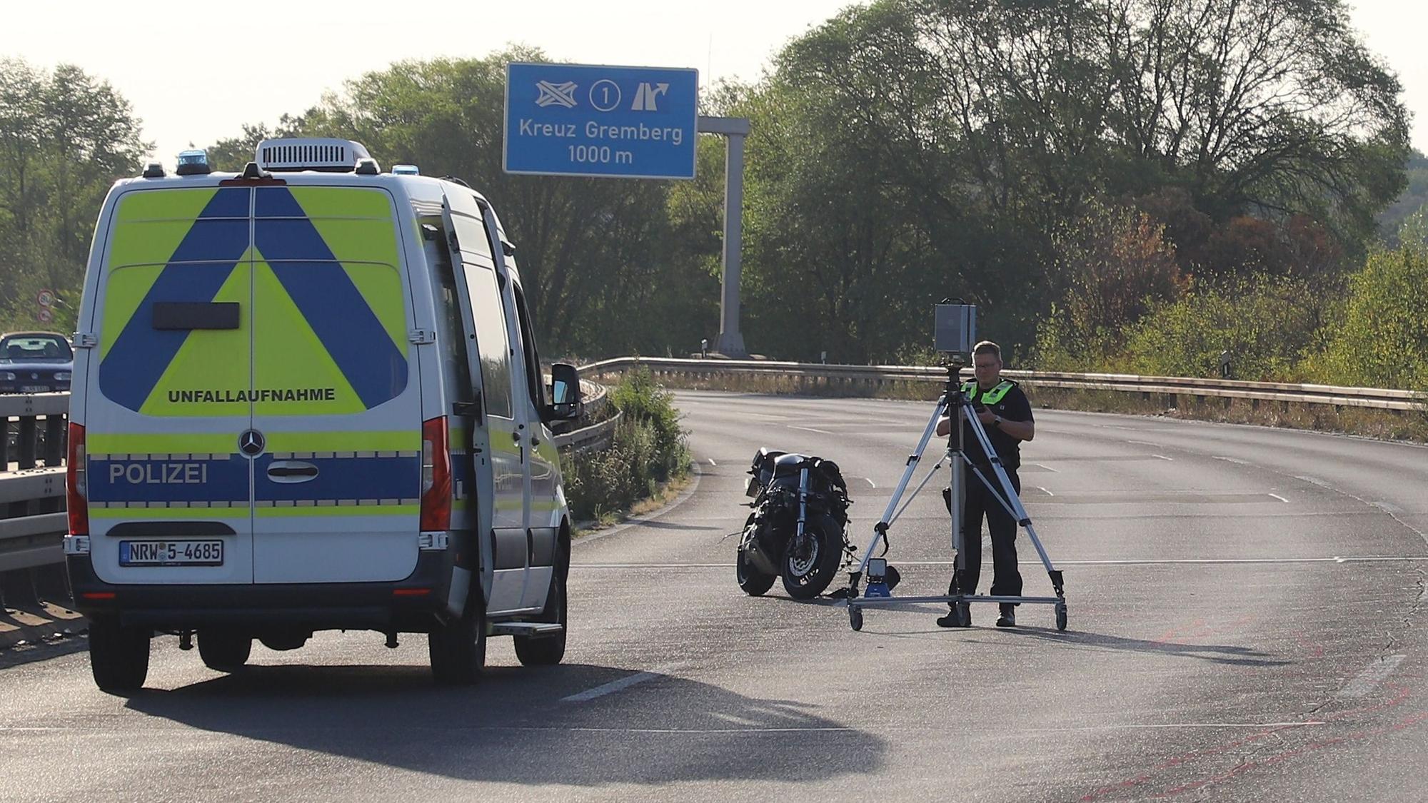 Ein Polizist nimmt Spuren mit einem Scanner auf. Bei einem Zusammenstoß zweier Motorräder auf der L124 in Köln sind zwei Männer ums Leben gekommen.