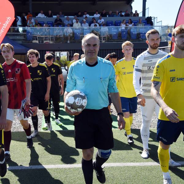 Angeführt vom Schiedsrichter, der den Ball in der Hand hat, laufen die Teams ein.