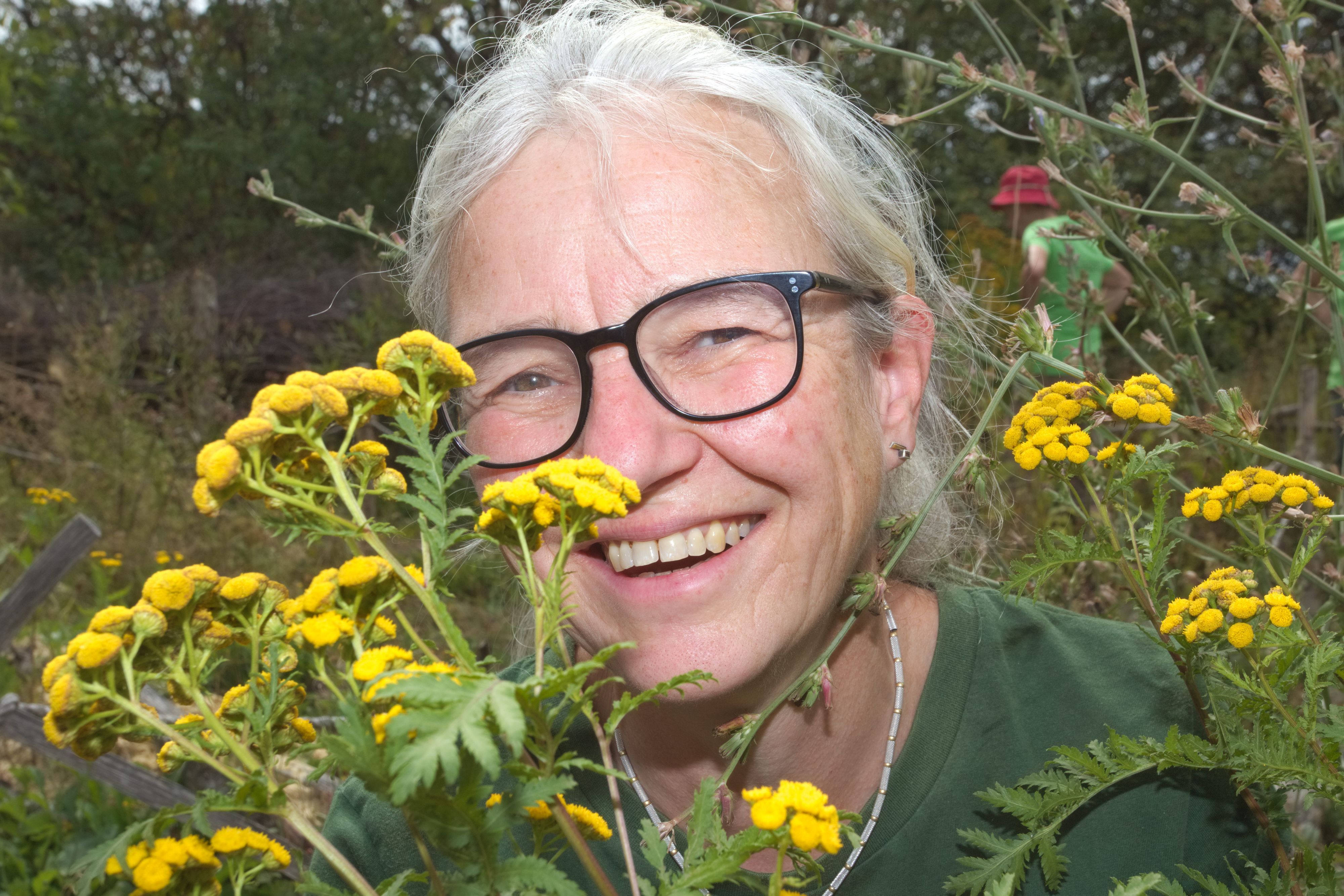 Eine Frau zeigt gelbe Blüten.