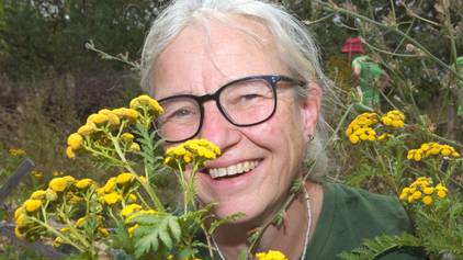 Eine Frau zeigt gelbe Blüten.