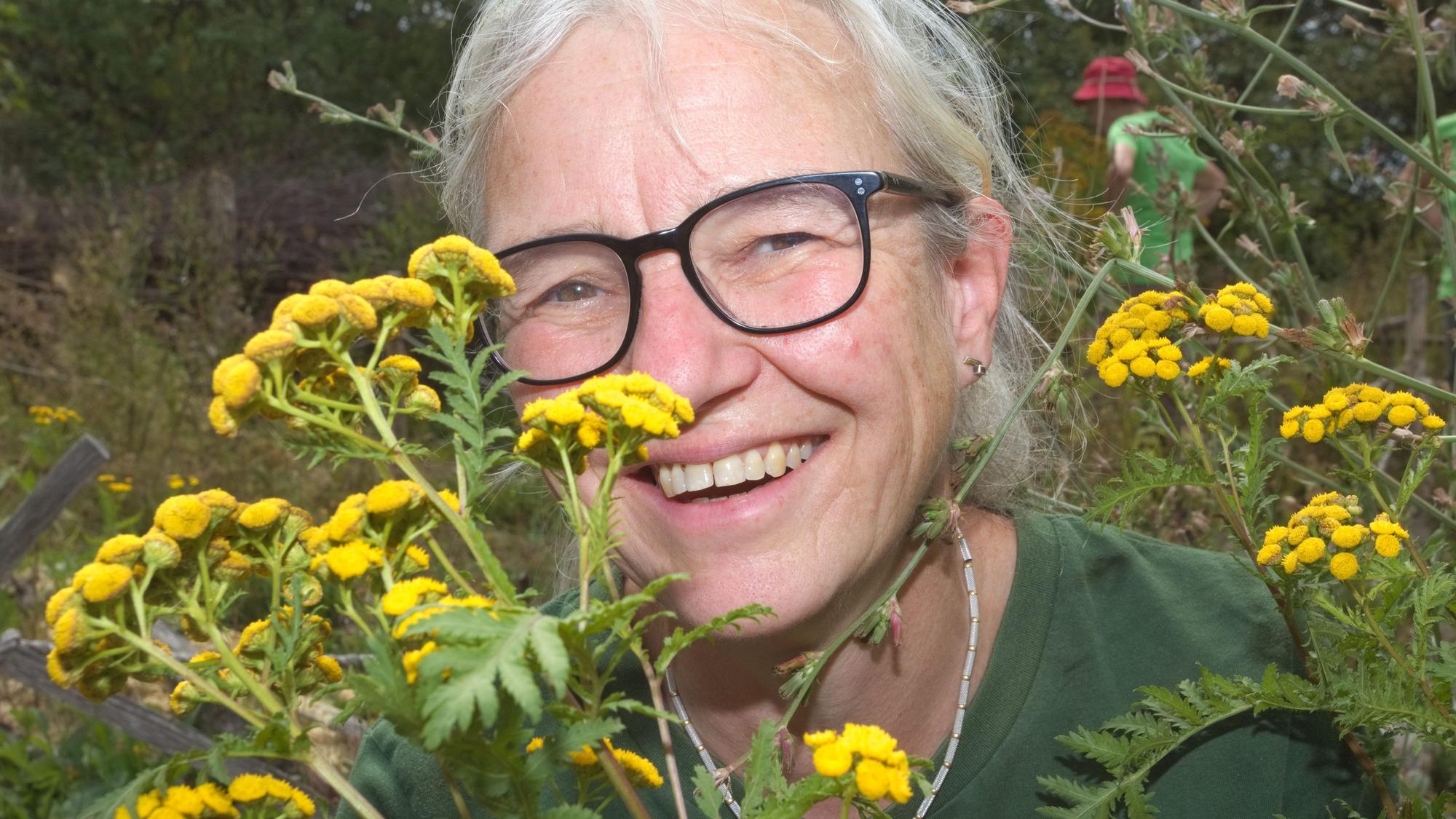 Eine Frau zeigt gelbe Blüten.