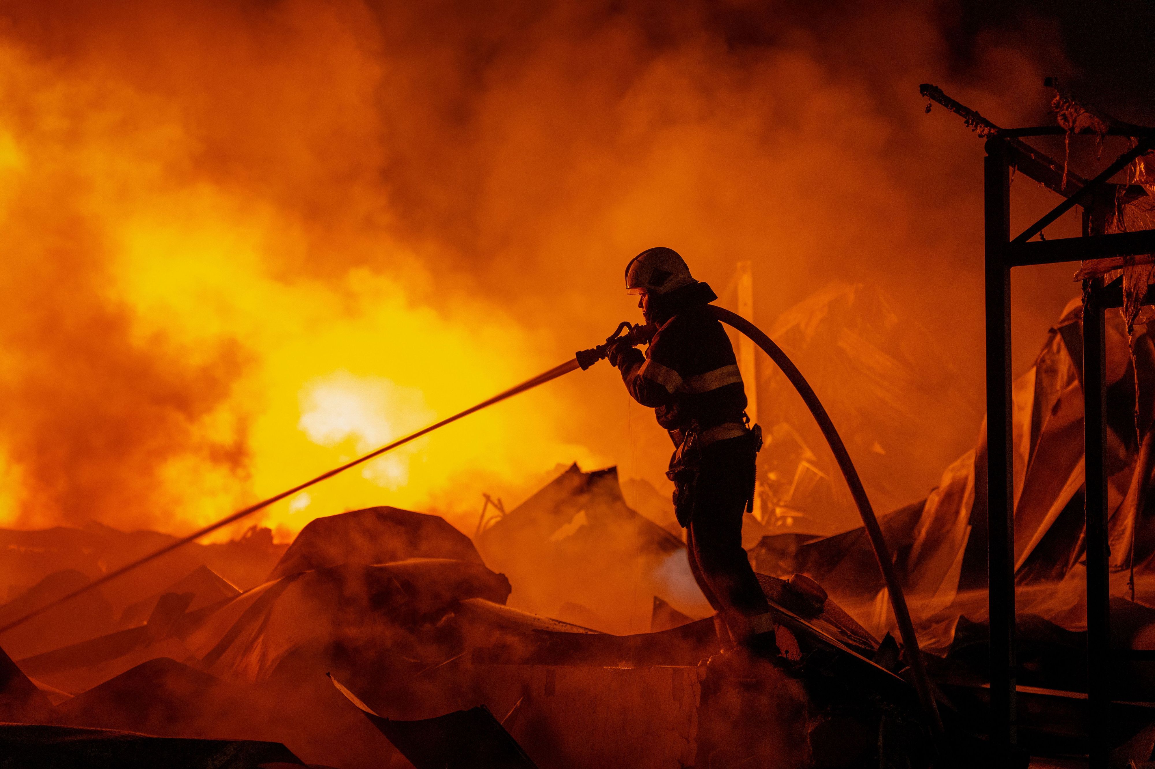 Feuerwehrleute löschten einen Brand, nachdem russische Raketen ein Lagerhaus getroffen hatten.