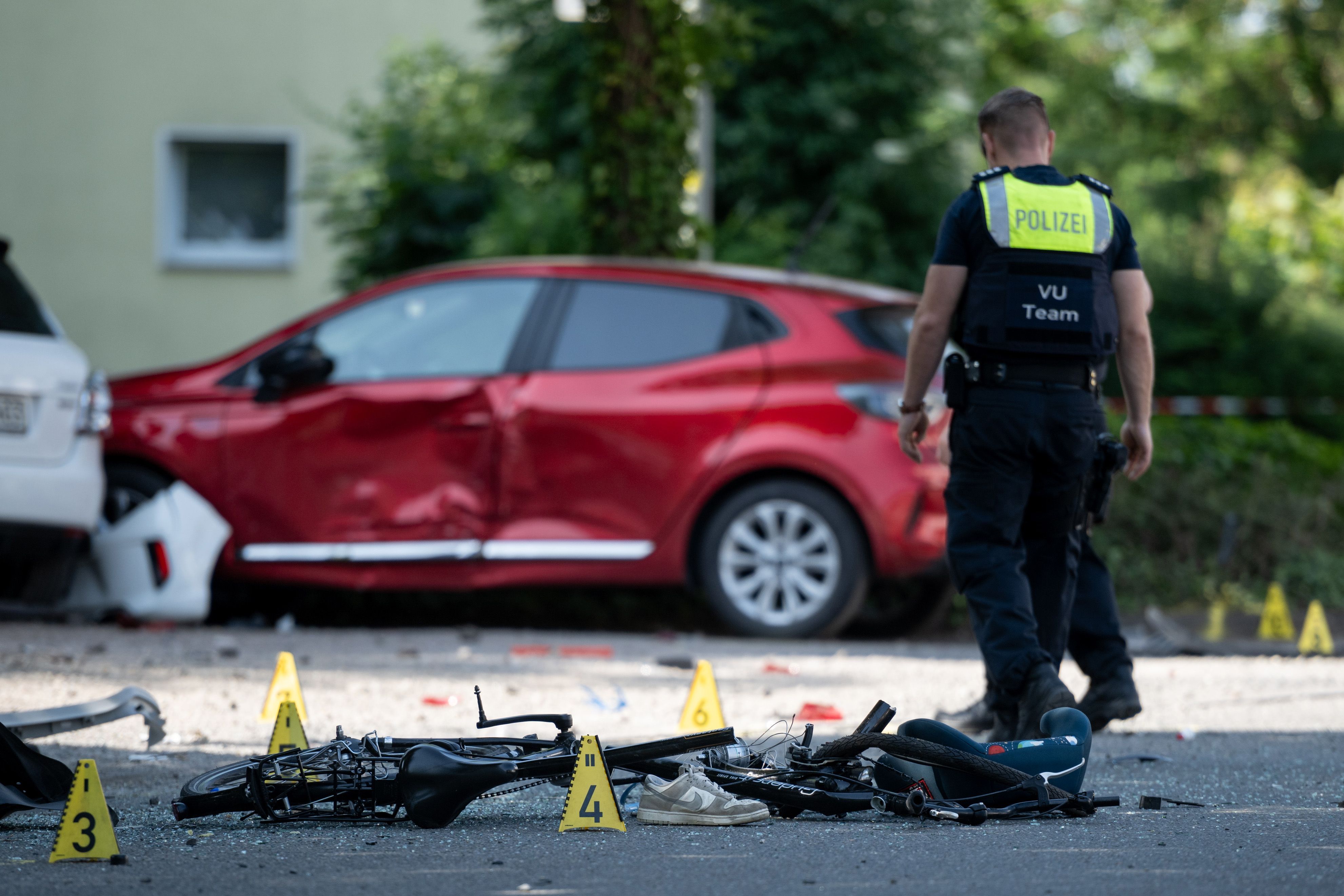 Ein Fahrrad liegt auf der Straße. Die Polizei sichert eine Unfallstelle.