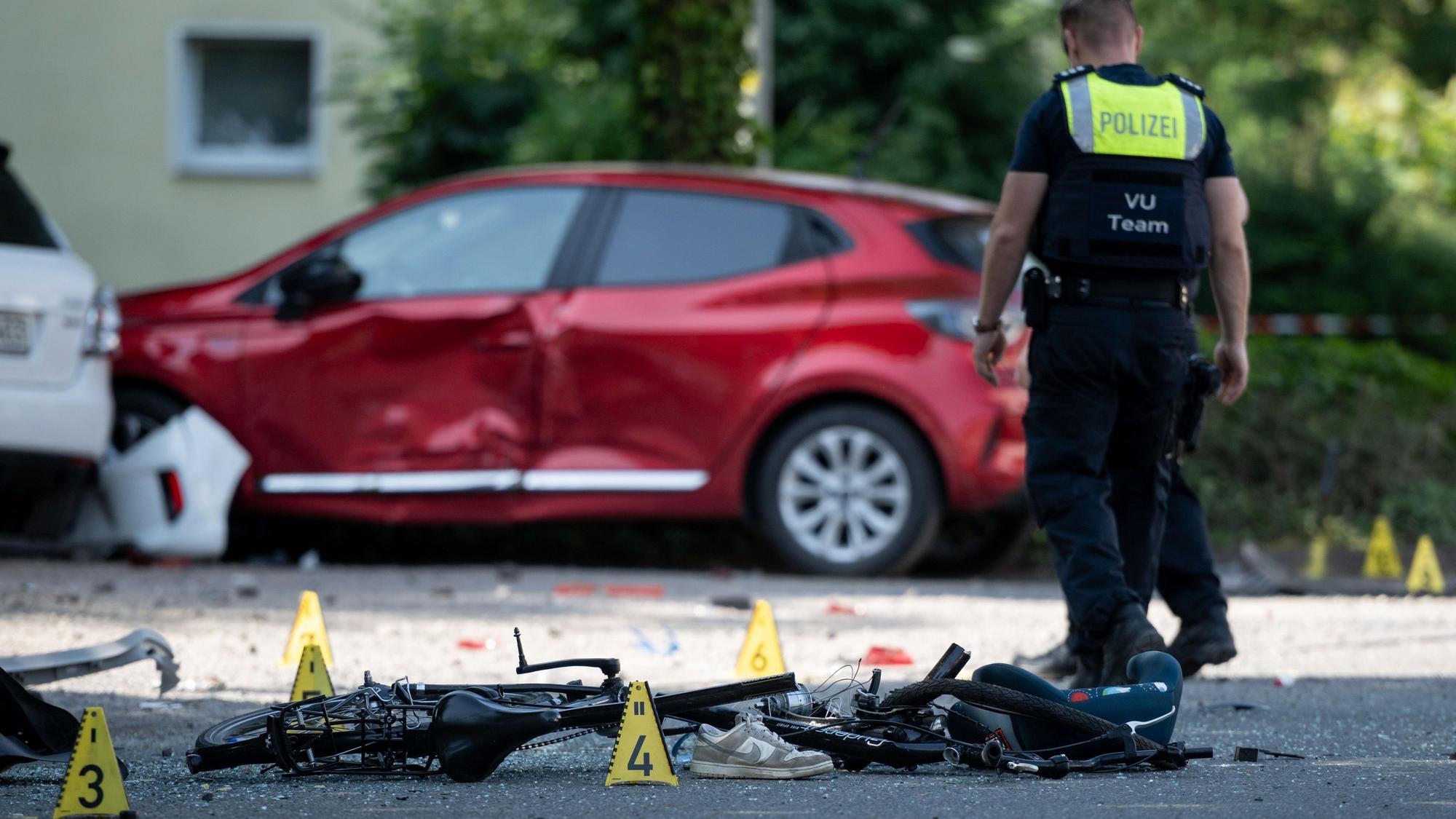 Ein Fahrrad liegt auf der Straße. Die Polizei sichert eine Unfallstelle.