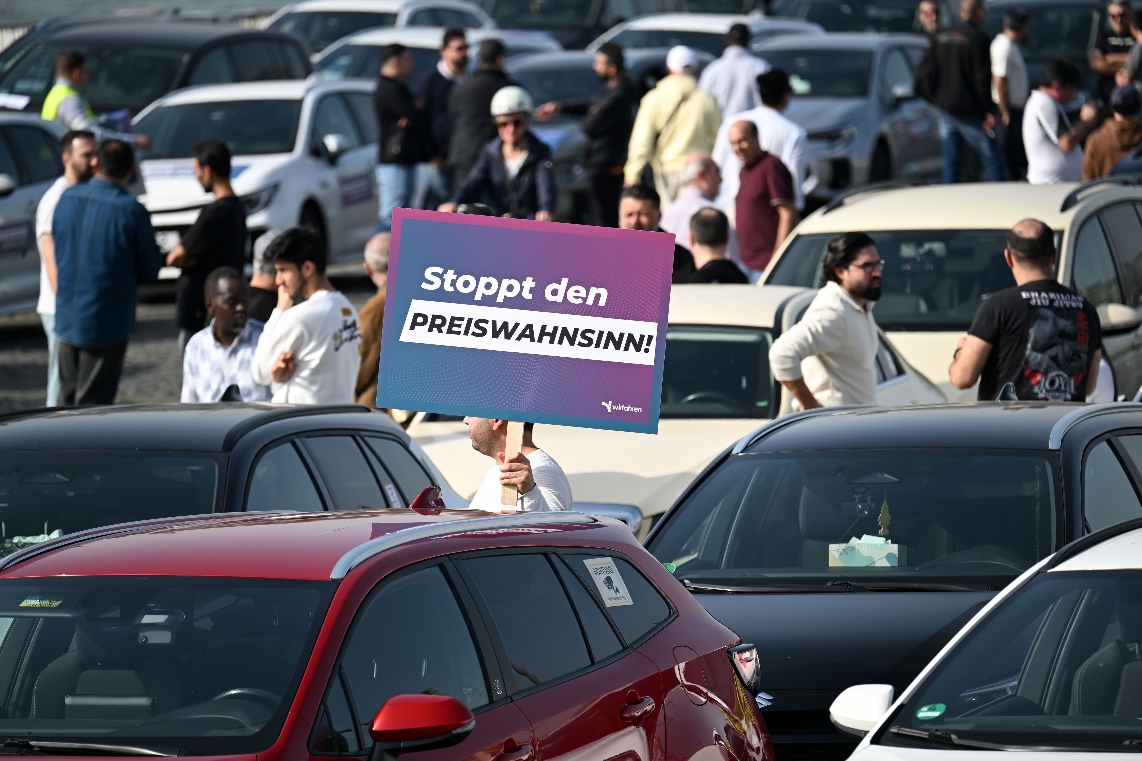 Teilnehmer einer Demonstration halten Schilder mit der Aufschrift „Stoppt das Preisdiktat“ in den Händen. Die Kundgebung im März 2026 richtete sich gegen Pläne der Stadt Köln zur Einführung von Mindestpreisen bei Unternehmen wie Uber und Bolt.
