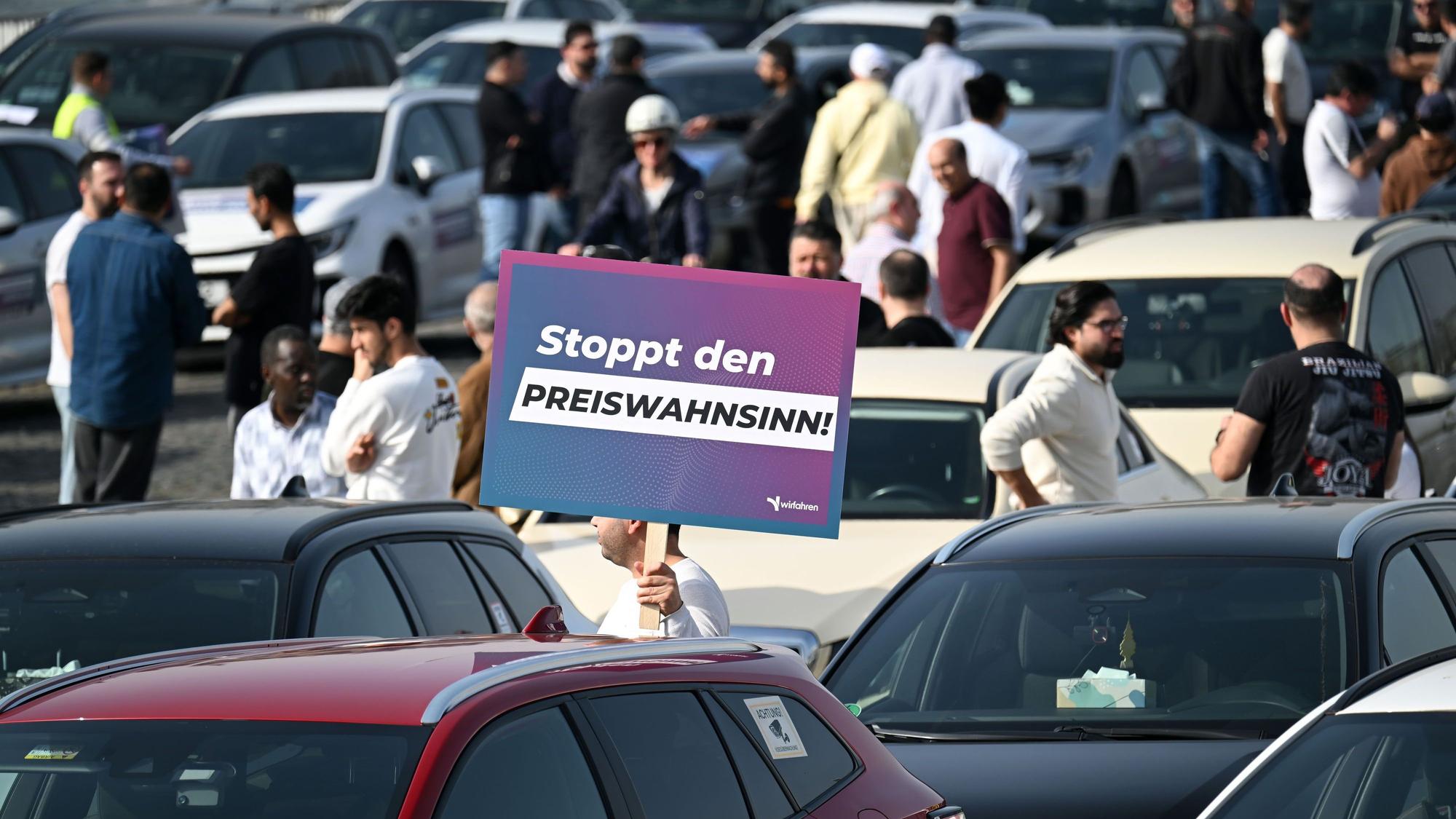 Teilnehmer einer Demonstration halten Schilder mit der Aufschrift „Stoppt das Preisdiktat“ in den Händen. Die Kundgebung im März 2026 richtete sich gegen Pläne der Stadt Köln zur Einführung von Mindestpreisen bei Unternehmen wie Uber und Bolt.