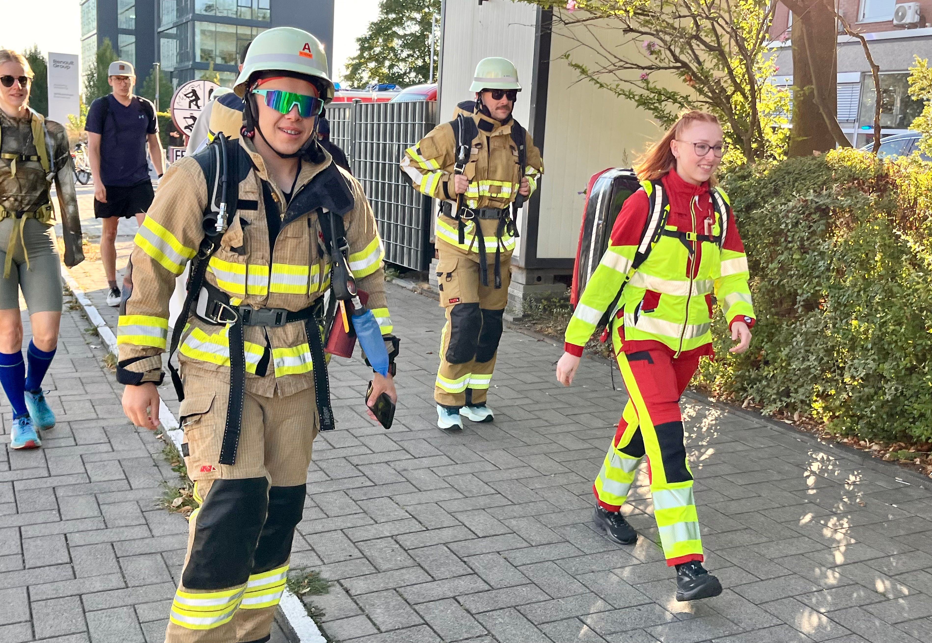 Feuerwehrleute in voller Montur machen sich auf den Weg.