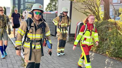 Feuerwehrleute in voller Montur machen sich auf den Weg.
