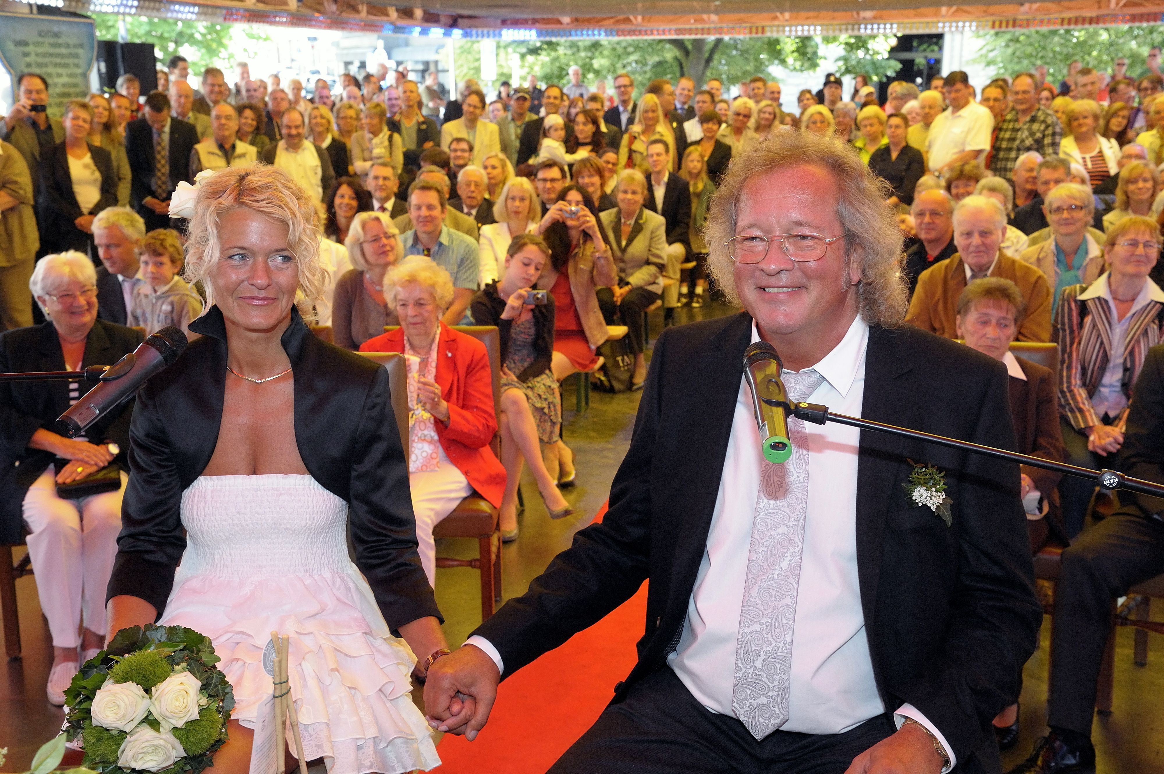 Ute und Burhardt Unrau sitzen bei ihrer Hochzeit vor den Gästen auf dem Autoscooter der Bergisch Gladbacher Kirmes.